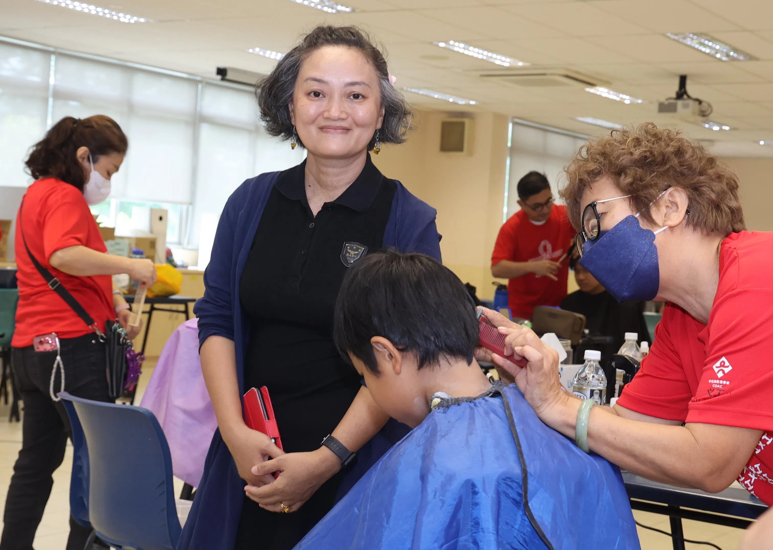 新学年从“头”开始，阿珍星期天带儿子参加嘉年华，陪他剪头发，让孩子以清爽的模样迎接新学年。（邬福梁摄）