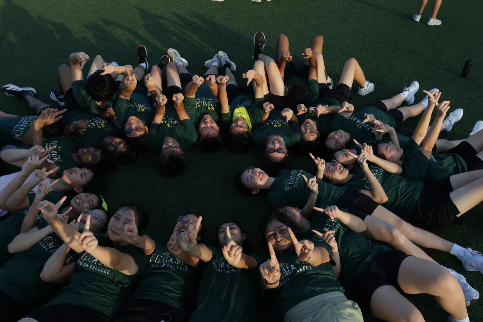 新生相聚在草地，在惬意的野餐氛围中分享美食，畅谈欢笑。（淡初摄影社提供）