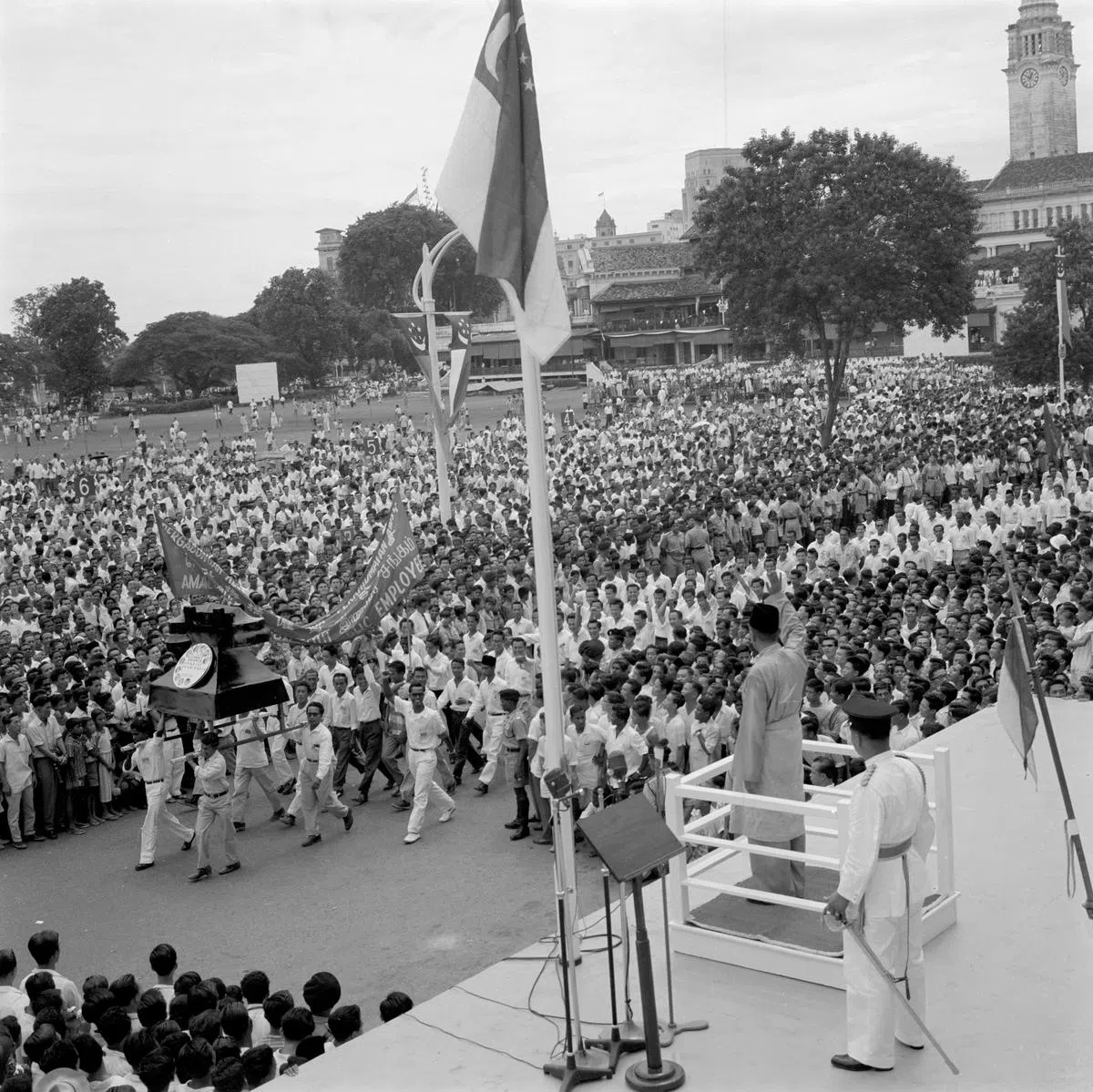 1959年12月3日，新加坡自治邦首任马来人国家元首尤索夫伊萨（Yusof Ishak）就职典礼在政府大厦前举行。新加坡邦旗升起，各队伍列队步过检阅台。(南洋商报）