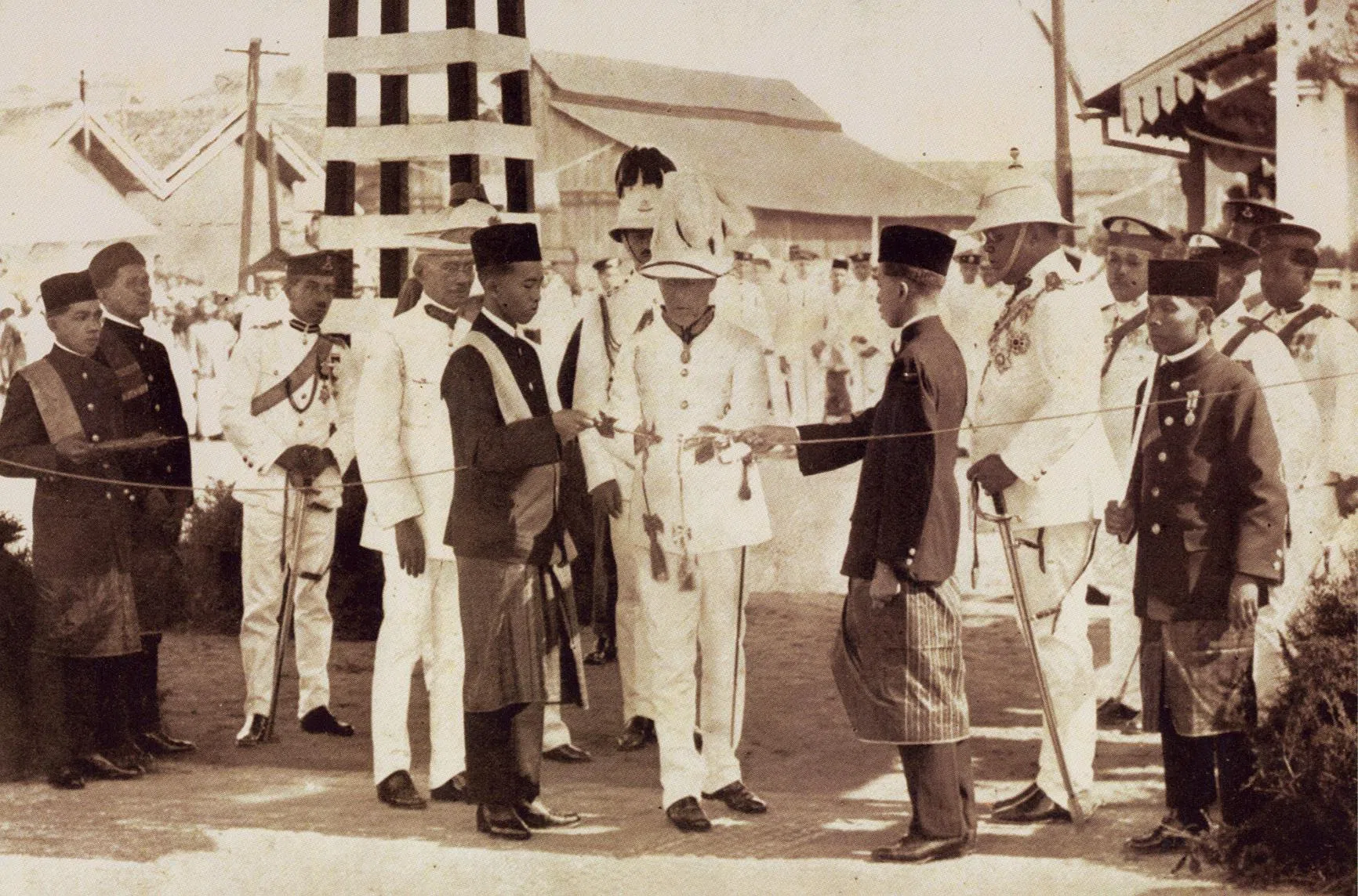 1924年6月28日，新加坡总督基里玛（中）及柔佛苏丹依布拉欣（右边左手持剑者）联合主持新柔长堤开幕仪式。上午9时15分，基理玛以依布拉欣赠予的金剪刀剪断黄丝带，象征长堤正式通行。（马来西亚国家档案馆）