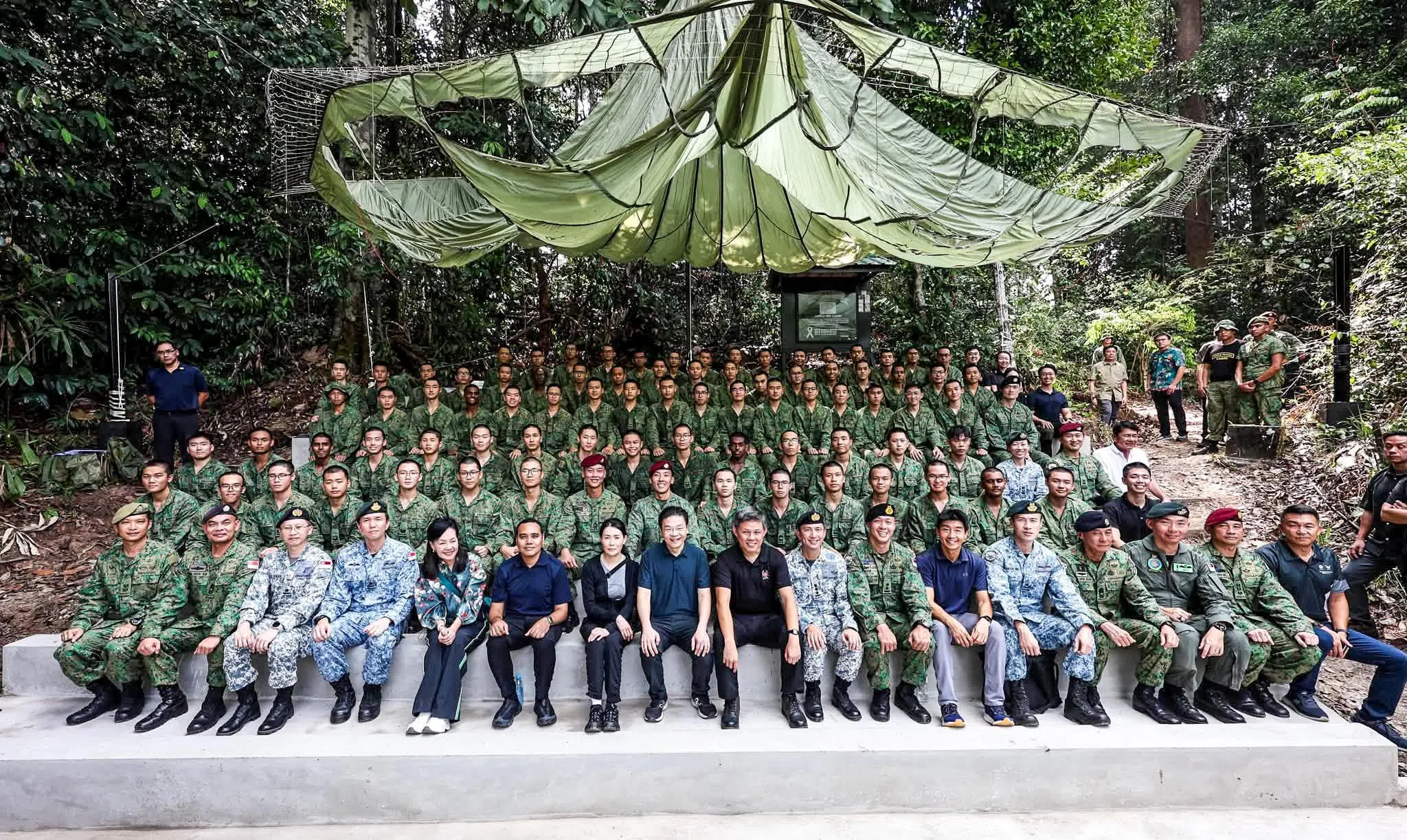 陪同黄总理（前排左八）到淡布隆探访我国军人的包括总理夫人吕子蕊（前排左七）、公共服务统筹部长兼国防部长陈振声（前排左九）、外交部兼内政部政务部长周凯年（前排左六）和国会议员王心妍（前排左五）。（数码发展及新闻部提供）