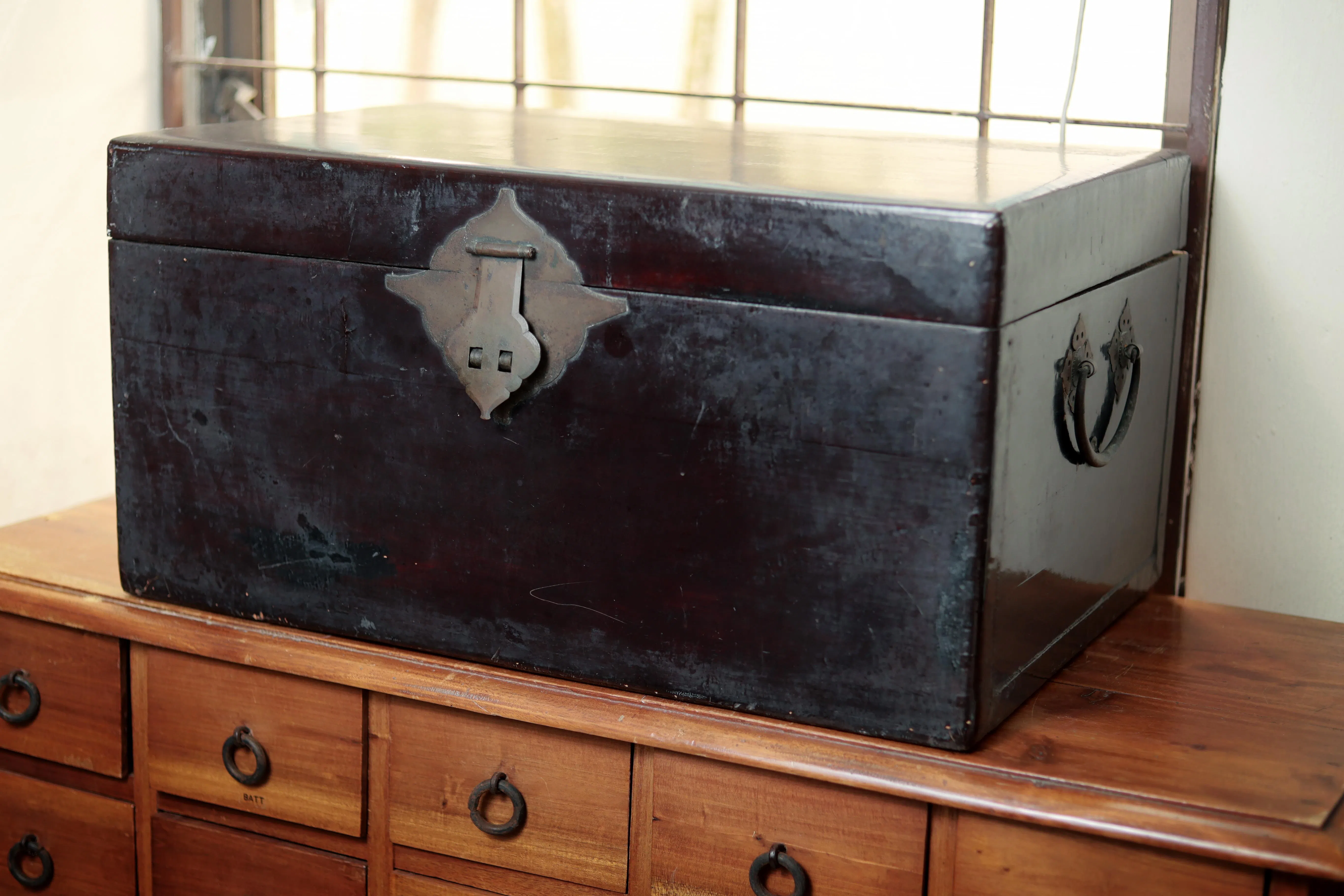 这口箱子从1937年随父母南来新加坡，就一直陪着周粲。（龙国雄摄）