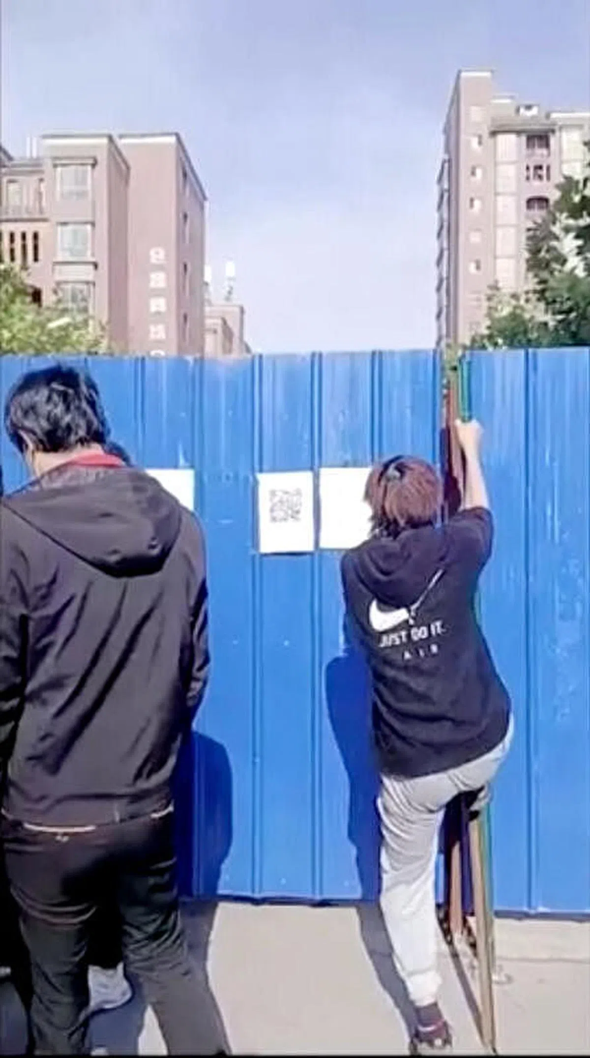 一名工人试图越过围栏逃离当地。（路透社）