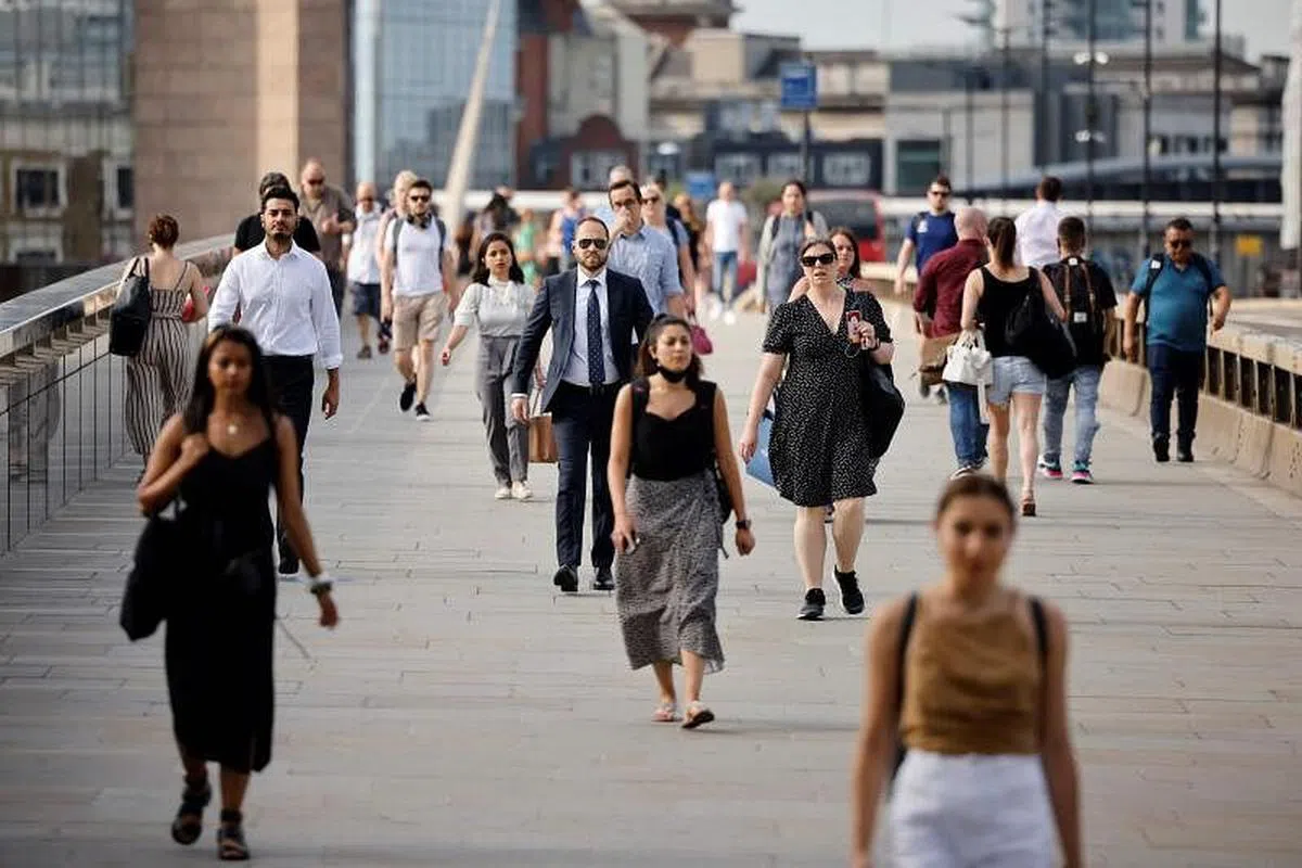 7月19日，英国解除几乎所有防疫限制，酒吧、餐馆和夜总会敞开大门，也不要求人们戴口罩，部分媒体称之为“自由日”。图为当天走在伦敦桥上的民众，好些人已不戴口罩。（法新社）