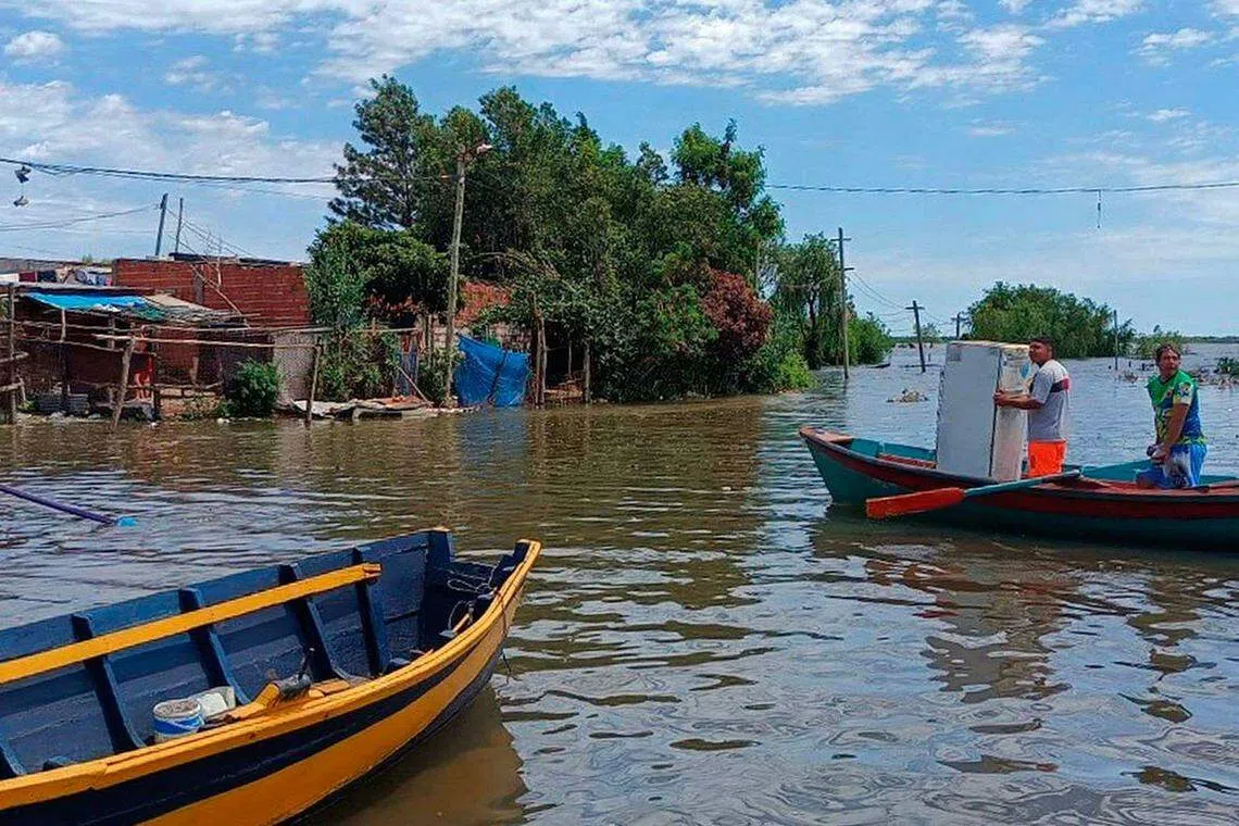 厄尔尼诺现象近日导致阿根廷、乌拉圭、巴拉圭和巴西遭受暴雨、洪水和河水上涨的冲击，造成人员死亡、失踪和数千人撤离。11月6日的照片显示，阿根廷科连特斯省（Corrientes）圣多美的居民在船只上，四处移动并打捞财物。（法新社）