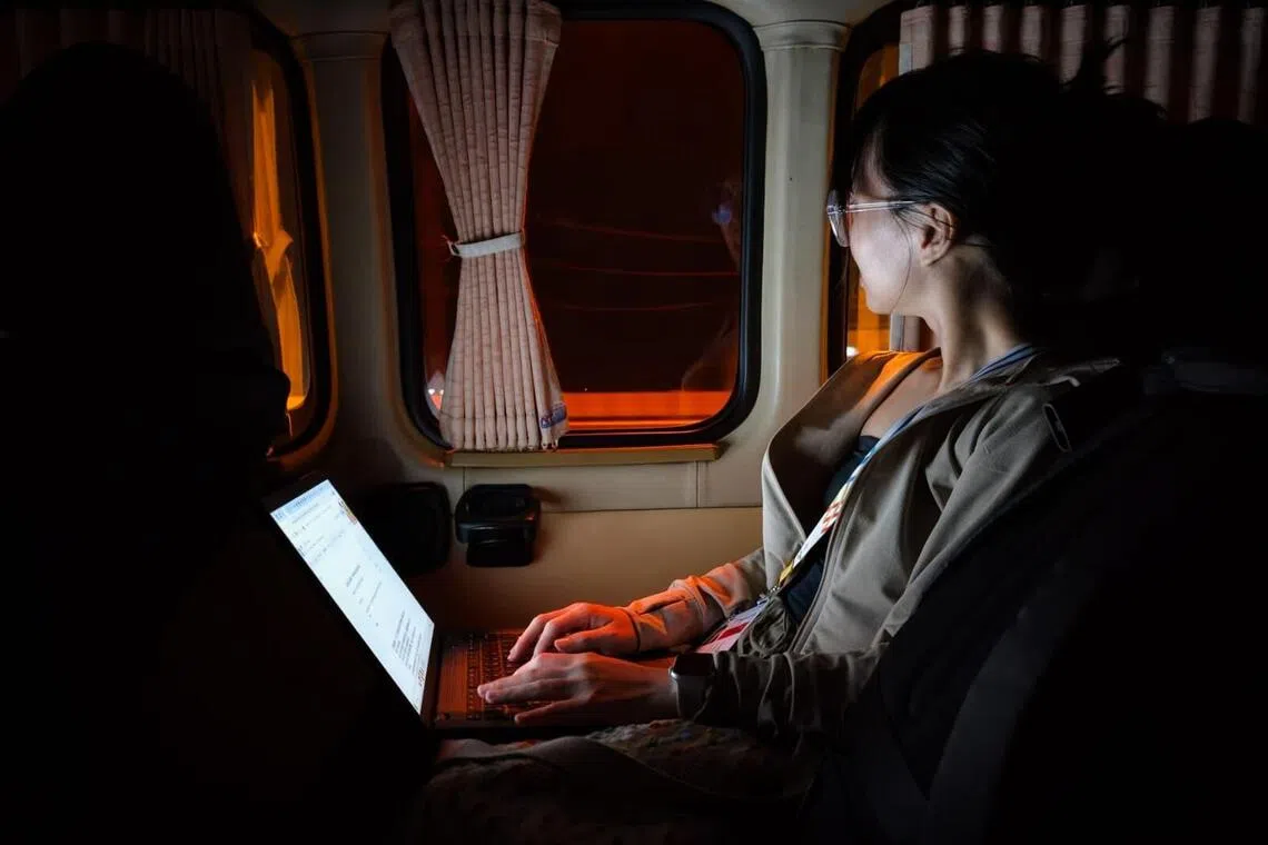 在泰国东运会出差期间，记者在车上赶稿件。（海峡时报）