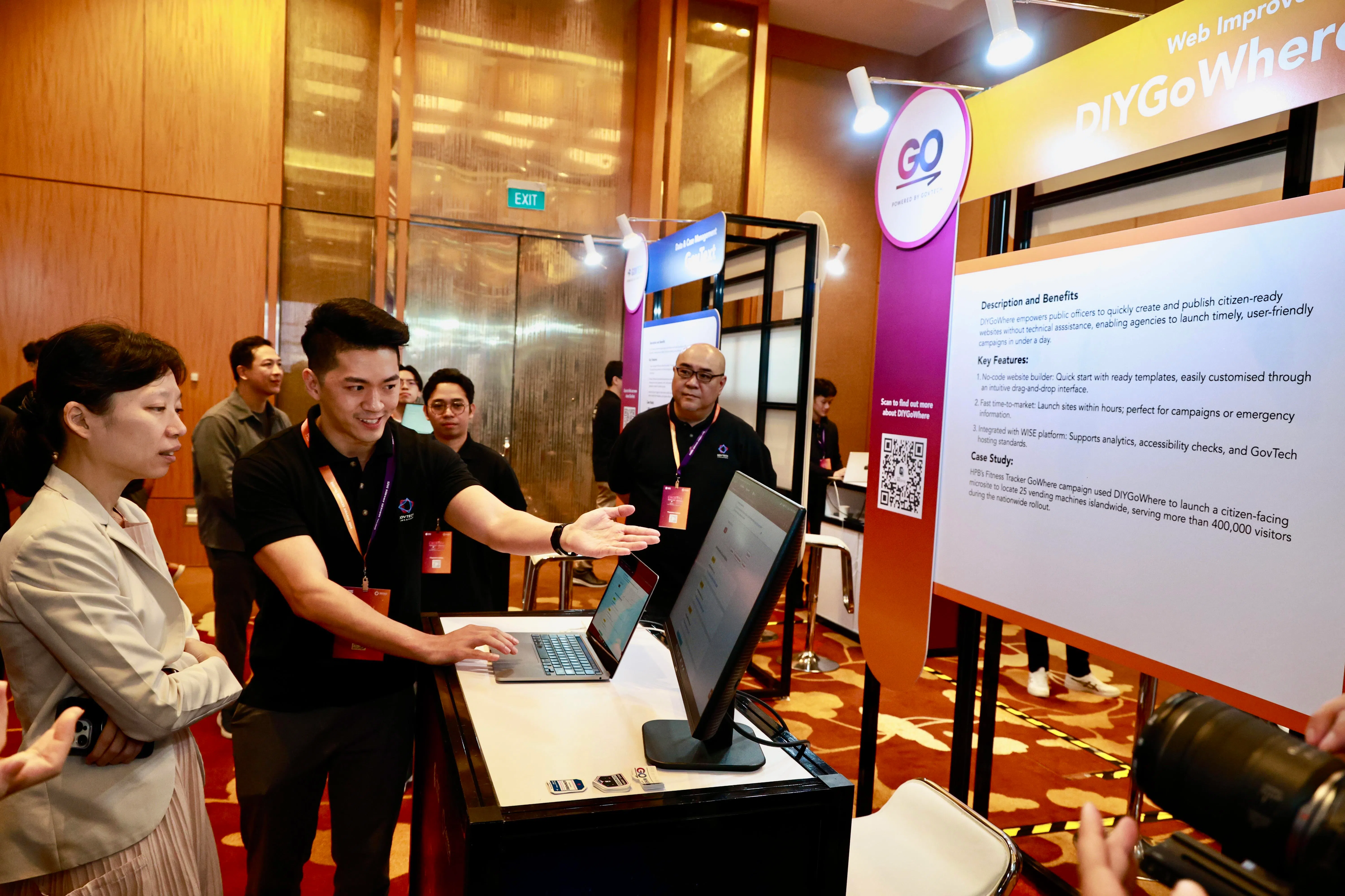 数码发展及新闻部兼教育部政务部长刘洁敏（左一）在政府数码服务奖活动上，了解新加坡政府科技局的数码产品DIYGoWhere。（特约陈来福摄）