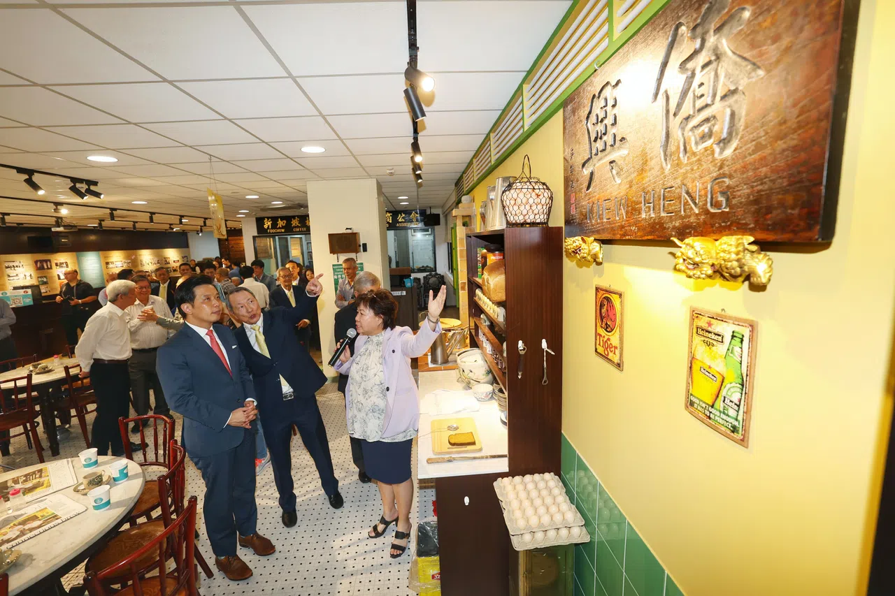 贸工部兼文化、社区及青年部政务部长陈圣辉（左），在福州咖啡酒餐商公会主席洪宝兴（中）陪同下，聆听福州咖啡酒餐商公会副总务及咖啡店文化馆策展人林美美的介绍。（郑一鸣摄）