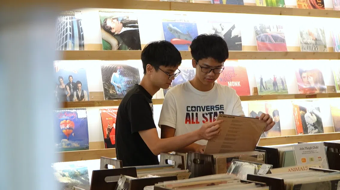 对60、70年代的音乐情有独钟的年轻人淘选黑胶唱片。（视频截图）