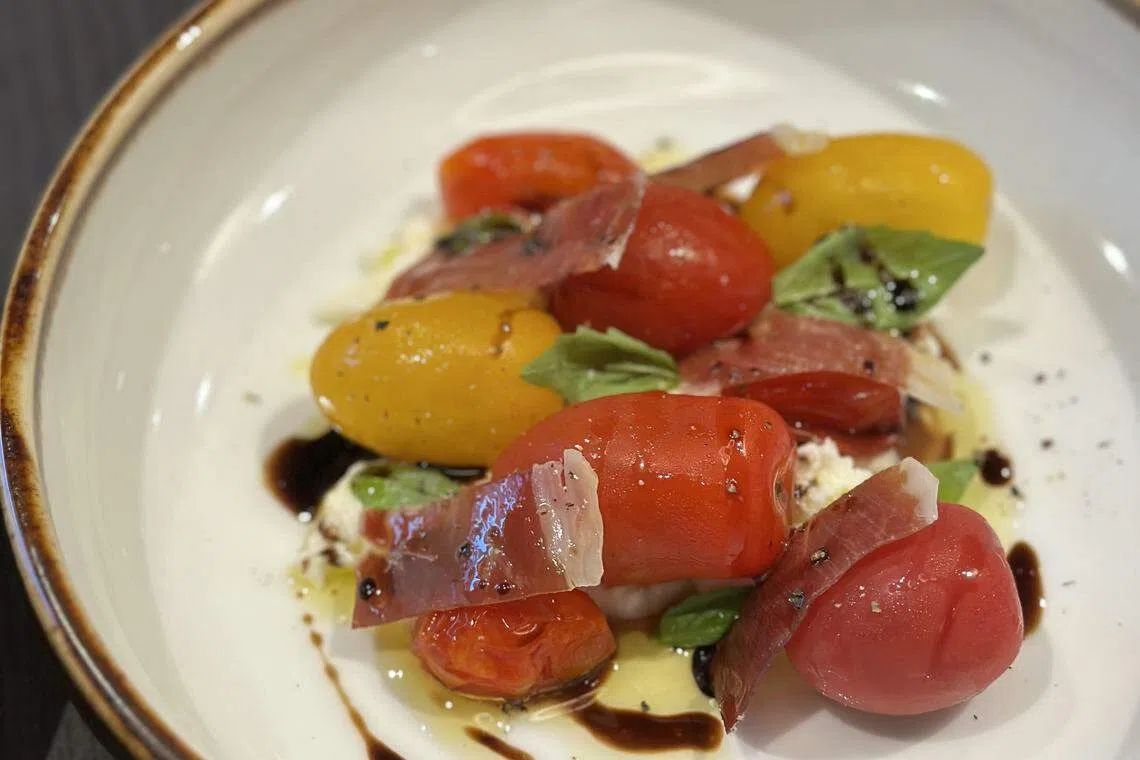 前菜祖传番茄结合咸香火腿、酸甜的发酵番茄和浓郁的烟熏丝翠奇亚奶酪。（餐馆提供）