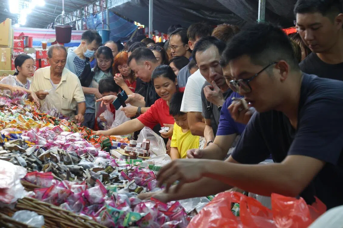 售卖果冻麻薯的摊主大年除夕降价出货，100公克只卖1元，吸引公众纷纷上前选购。（郑一鸣摄）