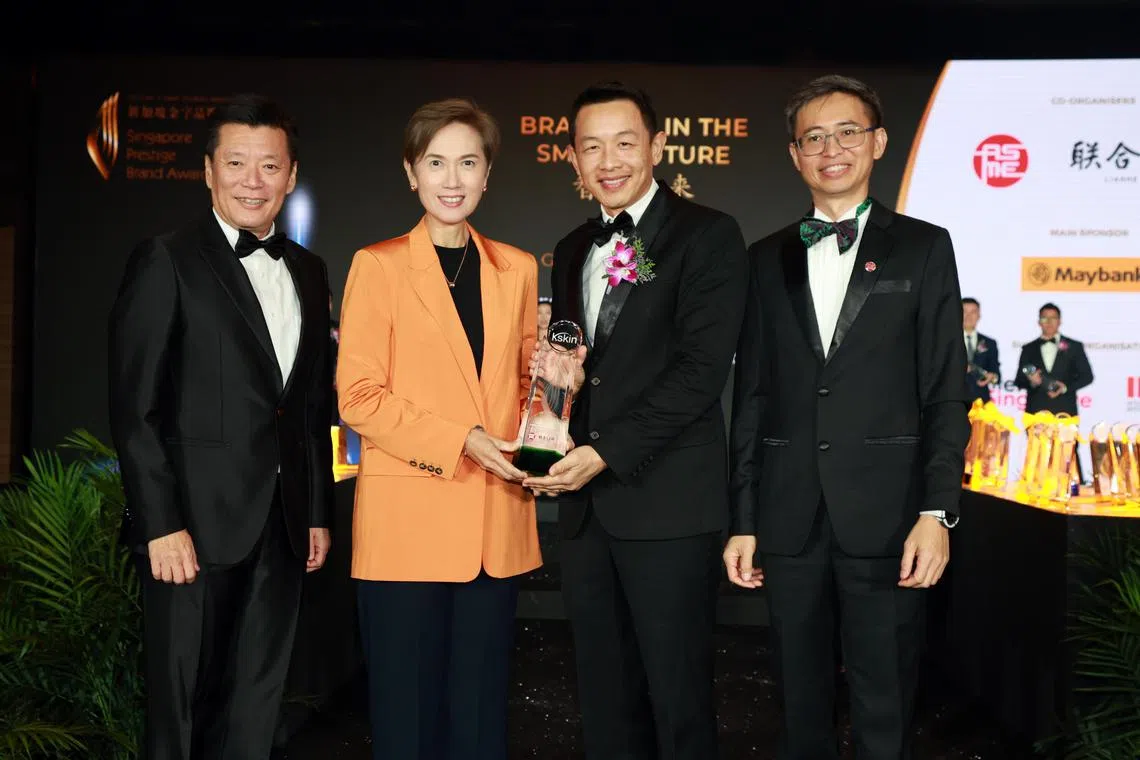 主宾数码发展及新闻部长杨莉明（左二）为潜质品牌总冠军Kskin全球品牌发展经理曾宪辉（右二）颁奖，左一是《联合早报》总编辑吴新迪，右一是中小企业商会会长洪煜。（邝启聪摄）