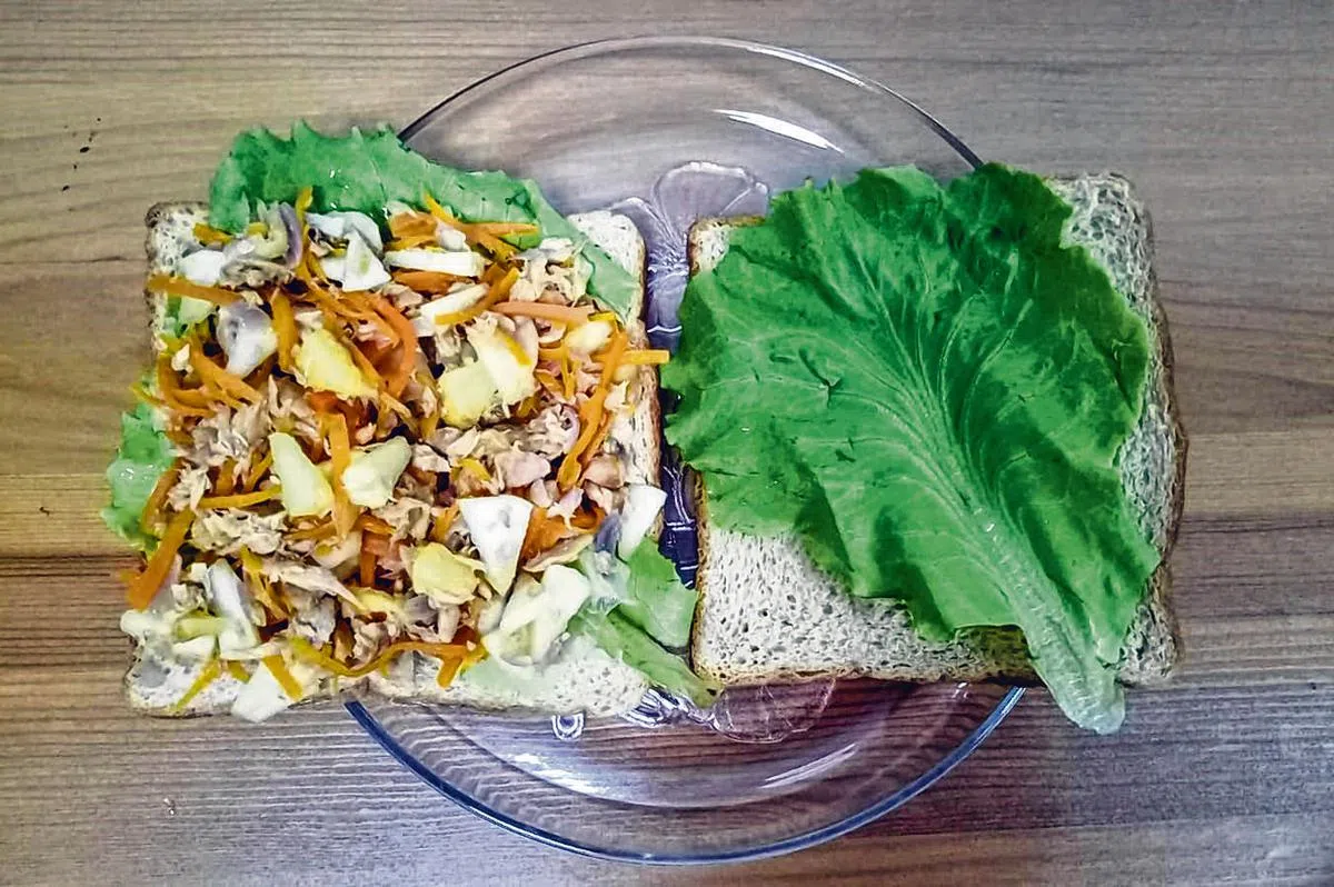 面包先铺上一叶生菜，再加上混合好的馅料，可避免全麦面包变得湿软。（受访者提供）