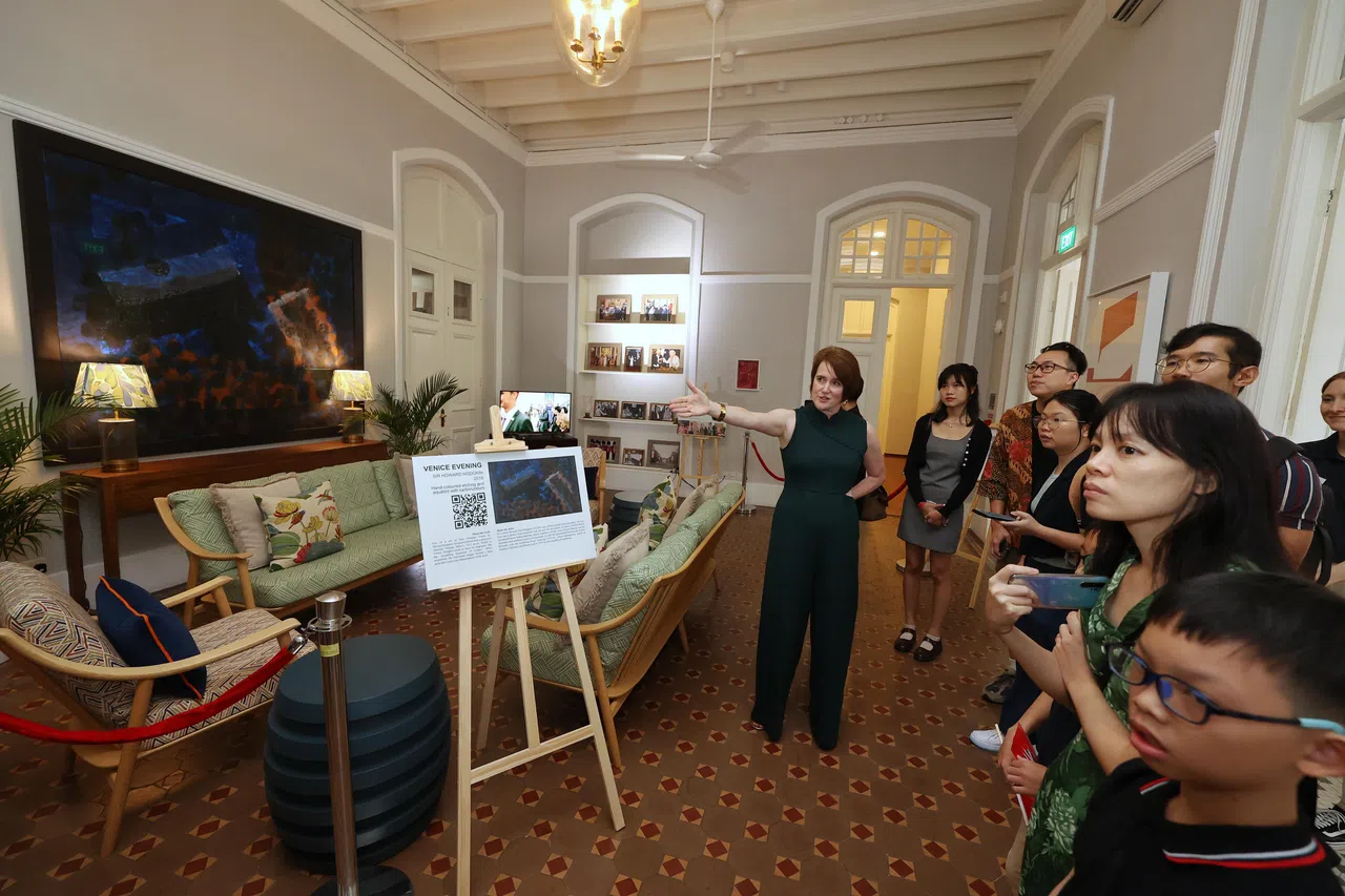 英国驻新加坡最高专员欧文（左一）为访客讲解伊甸堂内其中一个会客厅的陈设与墙上画作的寓意。（唐家鸿摄）