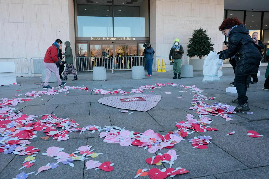 美国示威者2月14日在华盛顿特区的美国卫生与公众服务部门外，以彩纸在地上铺了心形图案，并写上“联邦雇员反抗政府效率部”的标语，表达对马斯克领导的政府效率部的不满。（法新社）