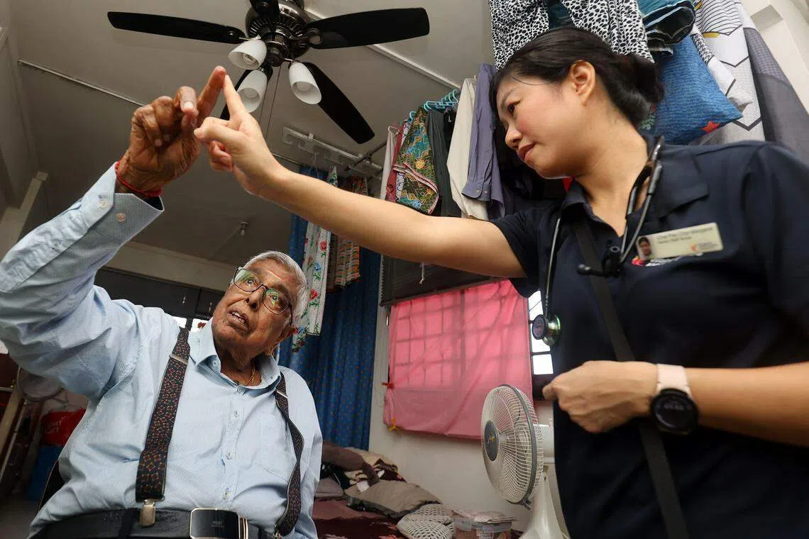 社区护士蔡佩琪（右）会定期到曾进行膝盖重建手术的卡拉辛加姆住家，为他进行简单的身体检查和护理服务。（萧紫薇摄）