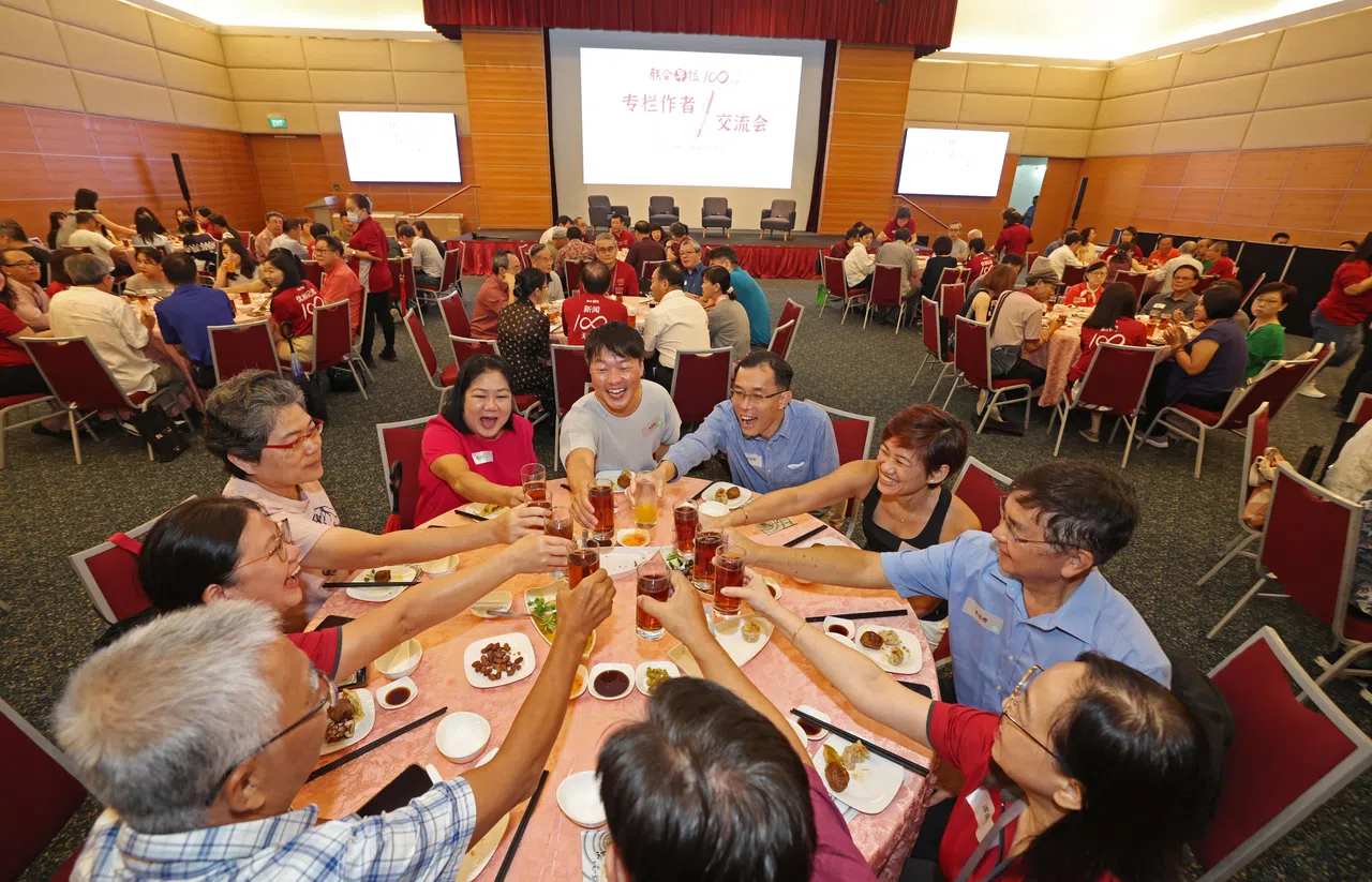 早报团队邀请约140名专栏作者参与在报业中心礼堂举行的午餐交流会，席间大家举杯，交换心得。（陈渊庄摄）