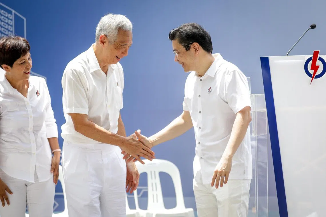 主政20年的国务资政李显龙（中），去年把总理职务交给黄循财总理（右），我国政治领导班子正式交替。图为人民行动党今年4月在大华银行大厦前广场举行的浮尔顿午间群众大会，出席者包括总理公署部长兼财政部及国家发展部第二部长英兰妮（左）。（档案照片）