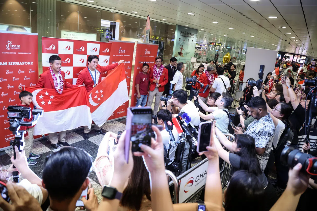 墨士廉和卢军汉手持国旗，接受来自各方的欢迎。（关俊威摄）