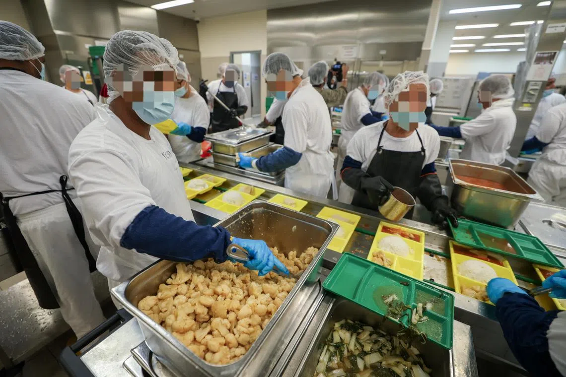 监狱厨房准备的菜色包括鸡肉、白菜、花菜和酱汁，值勤囚犯分工合作将餐盒打包好。（吴先邦摄）