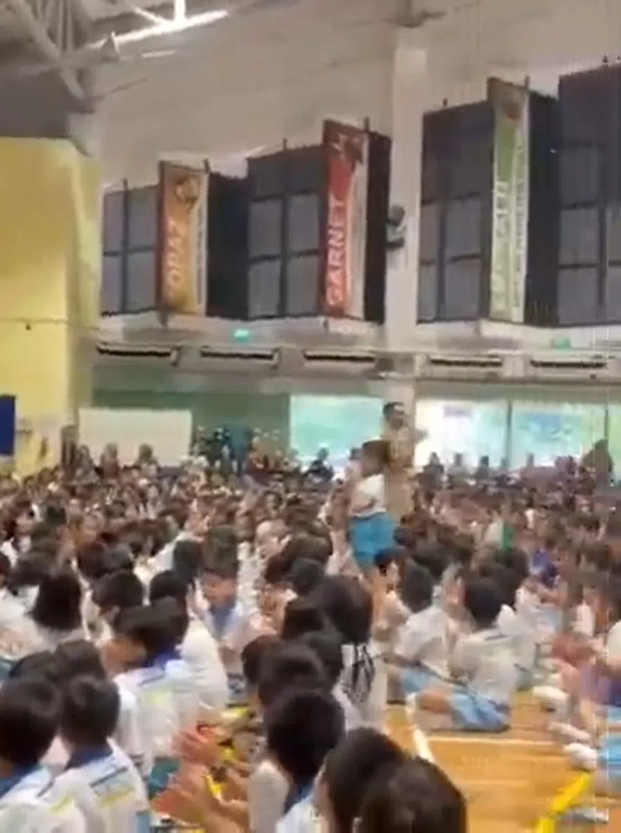 赛义夫（图中站立者）积极回收的行为在网上传开后，获得校方当众表扬；他还鞠躬向同学们表示感谢。（受访者提供）