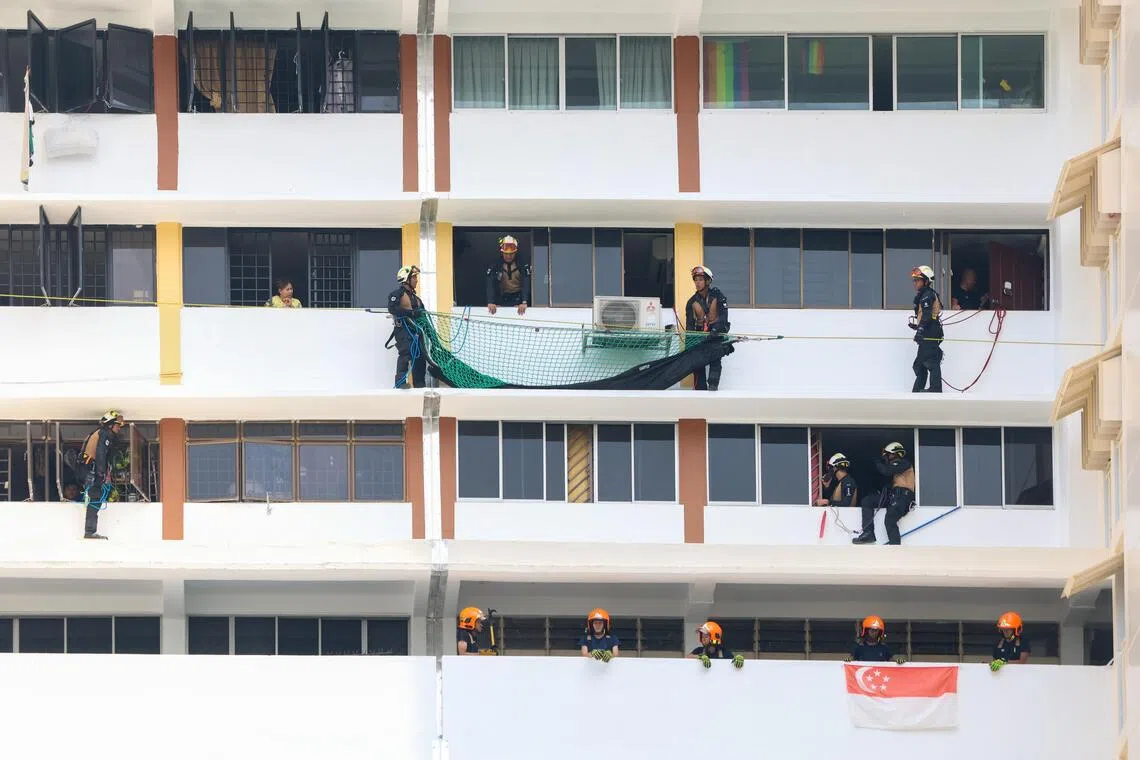 灾难拯救队人员在11楼事发单位的楼上楼下待命。（陈斌勤）