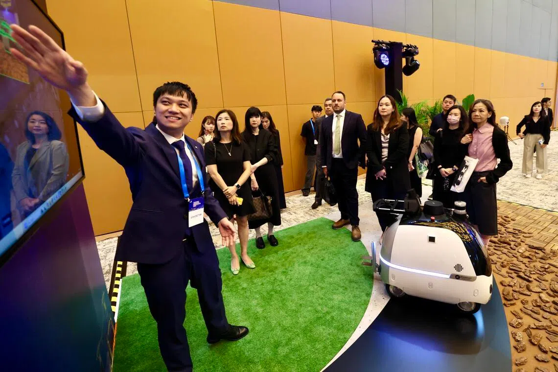10家公司的人工智能解决方案受邀在常年旅游大会上展示。图为本地公司dConstruct Robotics在向旅游业者介绍一款可用于侦测景区安全的监测巡逻机器人，以减少人力部署。（陈斌勤摄）