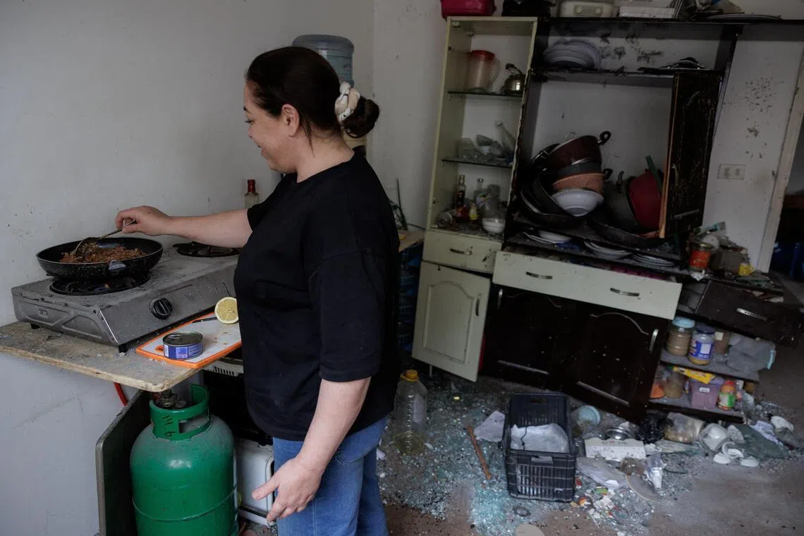 黎南边境城镇纳巴泰居民哈姆扎一家在以军空袭中幸存，随后举家逃到首都贝鲁特，在以黎停火生效后才终于返乡。从照片可以看到她家在空袭中受到的破坏。（路透社）