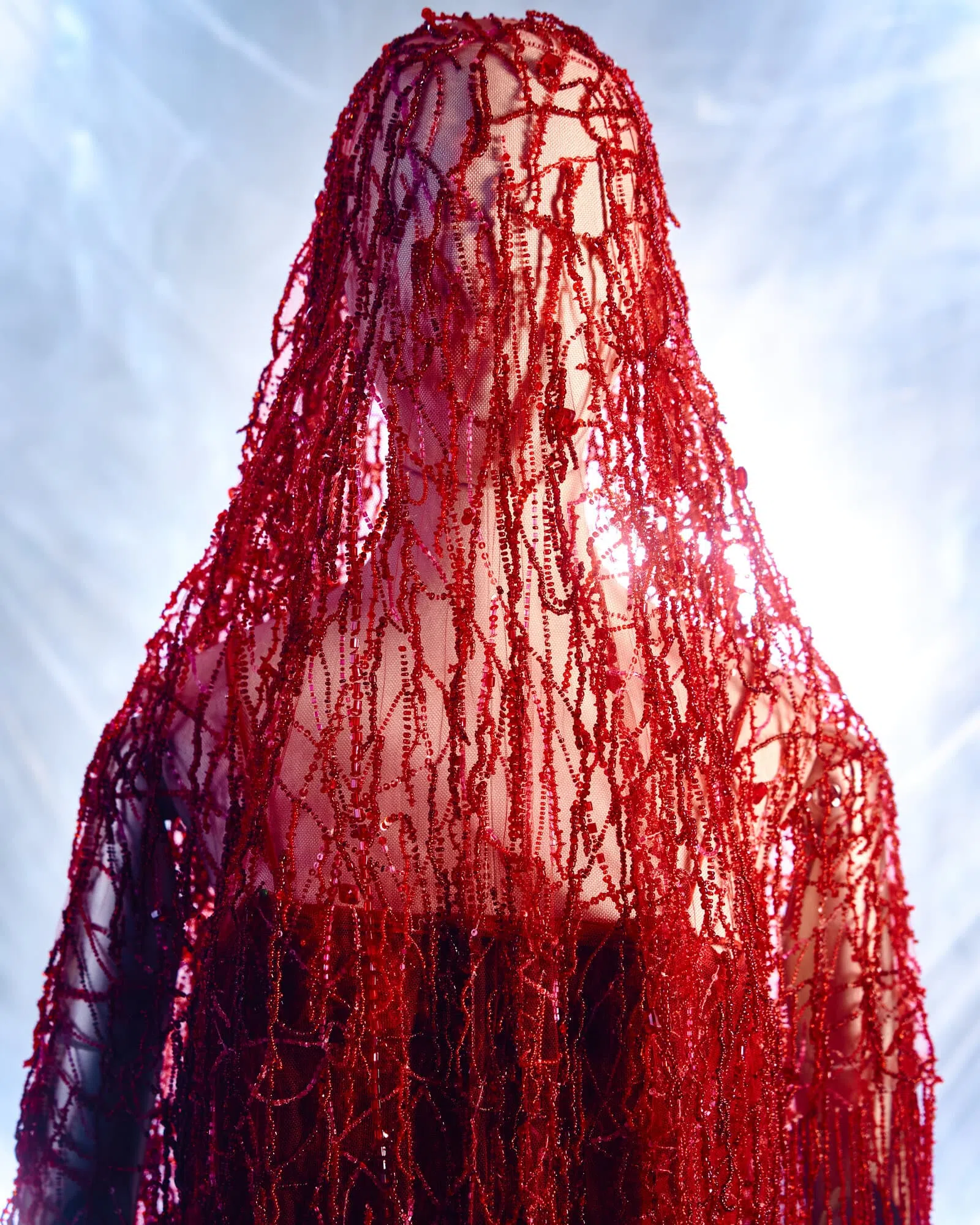 近看红色晚装的披肩，原来是由无数颗红色珠子所串成，还能当作面纱。（取自阿玛尼资料库网站）