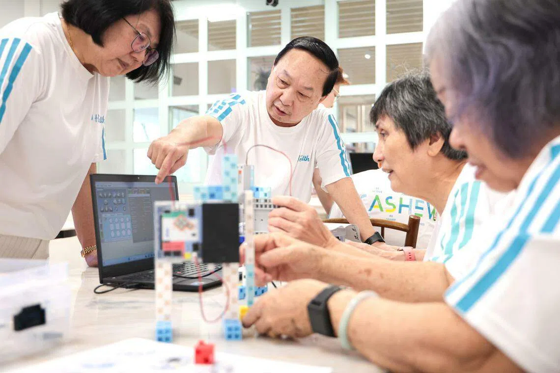 海军部村庄的职总保健活跃乐龄中心，推出新颖的机器人（robotics）课程，由完成课程的年长者教导新学员。（李冠卫摄）