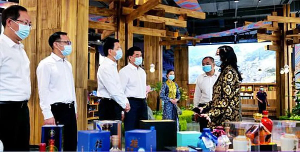 广西壮族自治区人大常委会副主任、党组副书记张晓钦（左三）等参观中国—东盟特色商品汇聚中心，现场展示广西网红食品“螺蛳粉”、东南亚国家咖啡、燕窝、芒果干，及巴基斯坦工业品等。（汇聚中心提供）