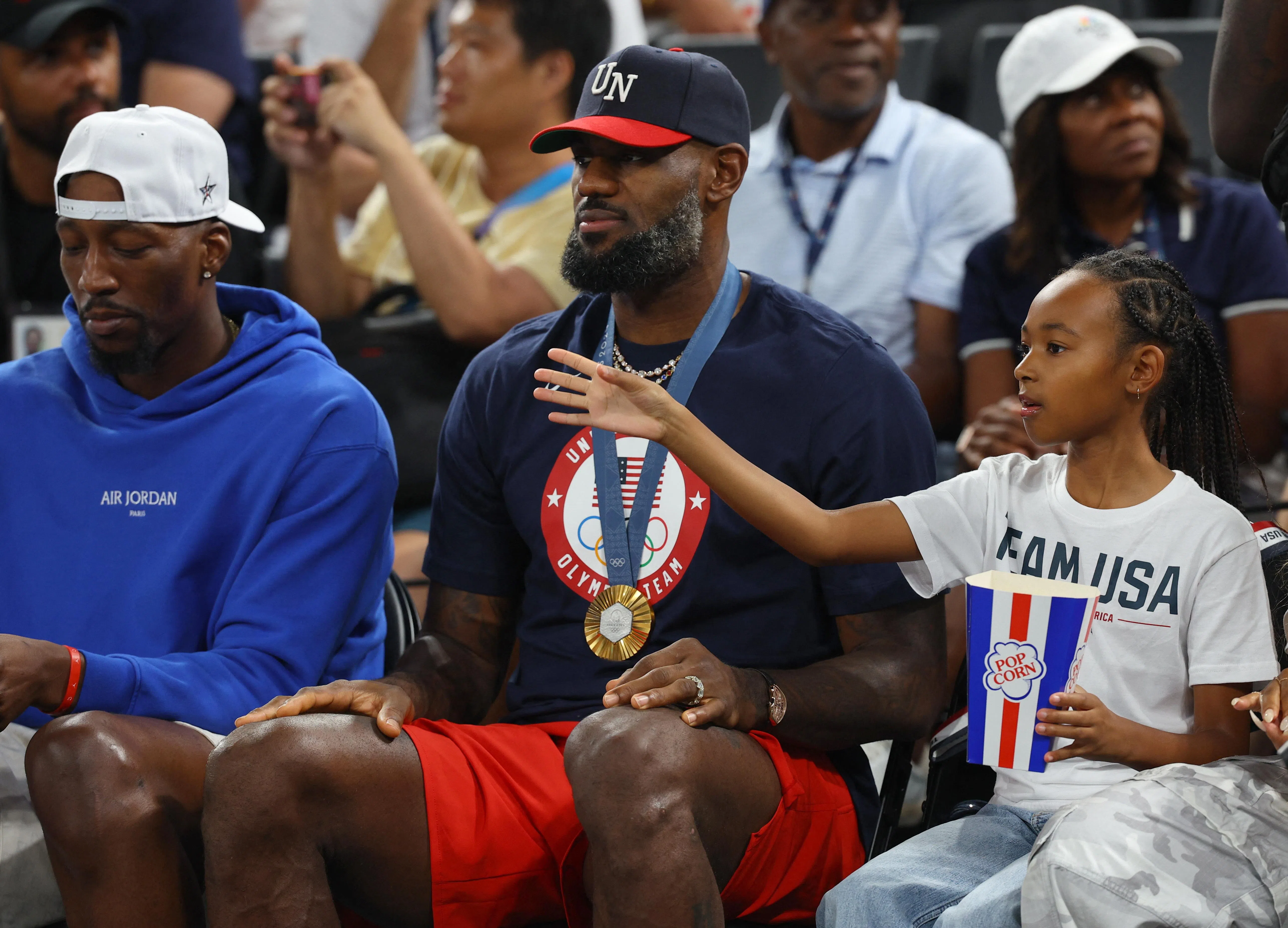 美国篮球巨星詹姆斯（中）带着刚赢得的金牌观看女篮决赛。（路透社）