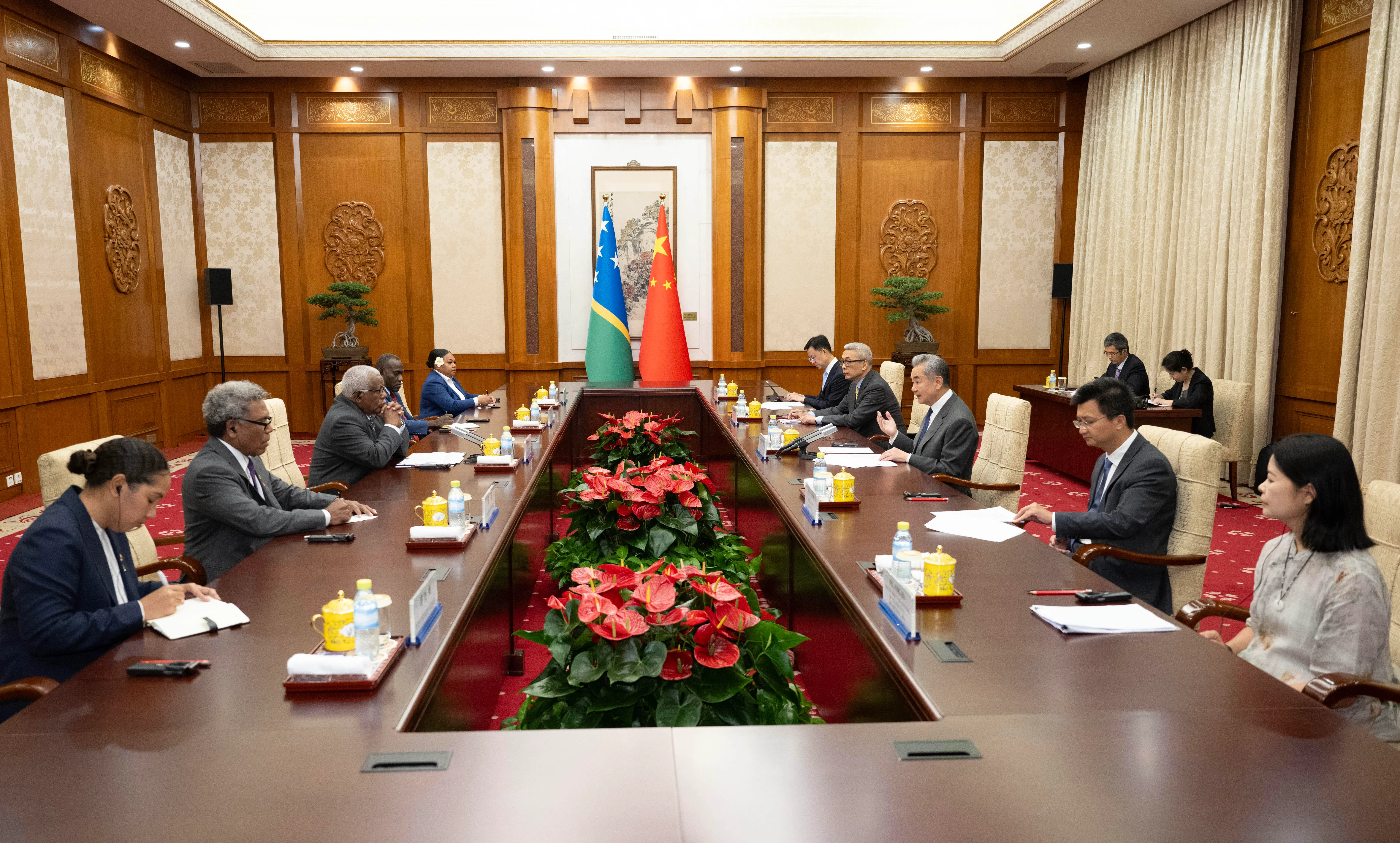 中国外长王毅（右三）7月14日在北京同所罗门群岛外交和外贸部长霍尼普维拉（左三）举行会谈。（新华社）
