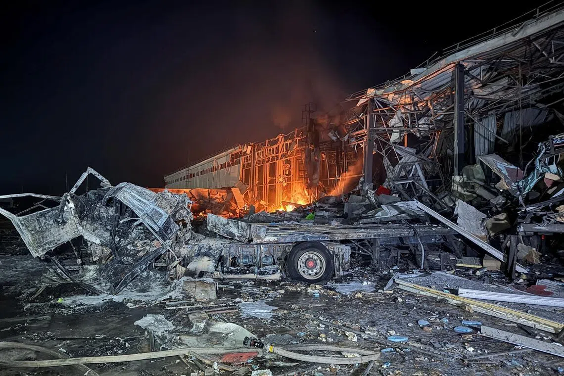 1月13日，乌克兰哈尔科夫一家私人快递公司枢纽遭到俄罗斯导弹袭击后起火燃烧。（路透社）