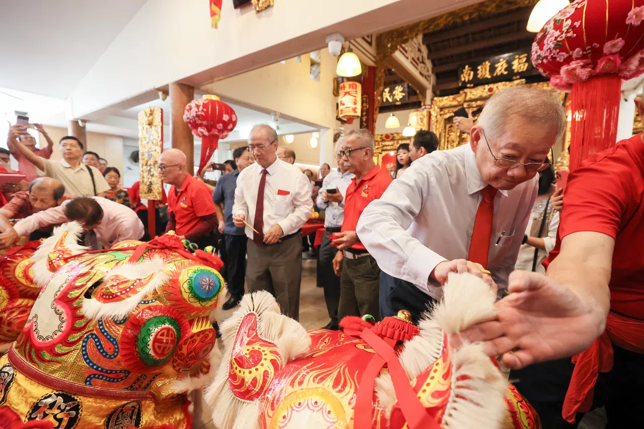 琼州天后宫主席王振胡（右）和海南会馆会长潘家海（中，白衬衫打领带者）为海南狮开光讨个好彩头。（卓祾祎摄）