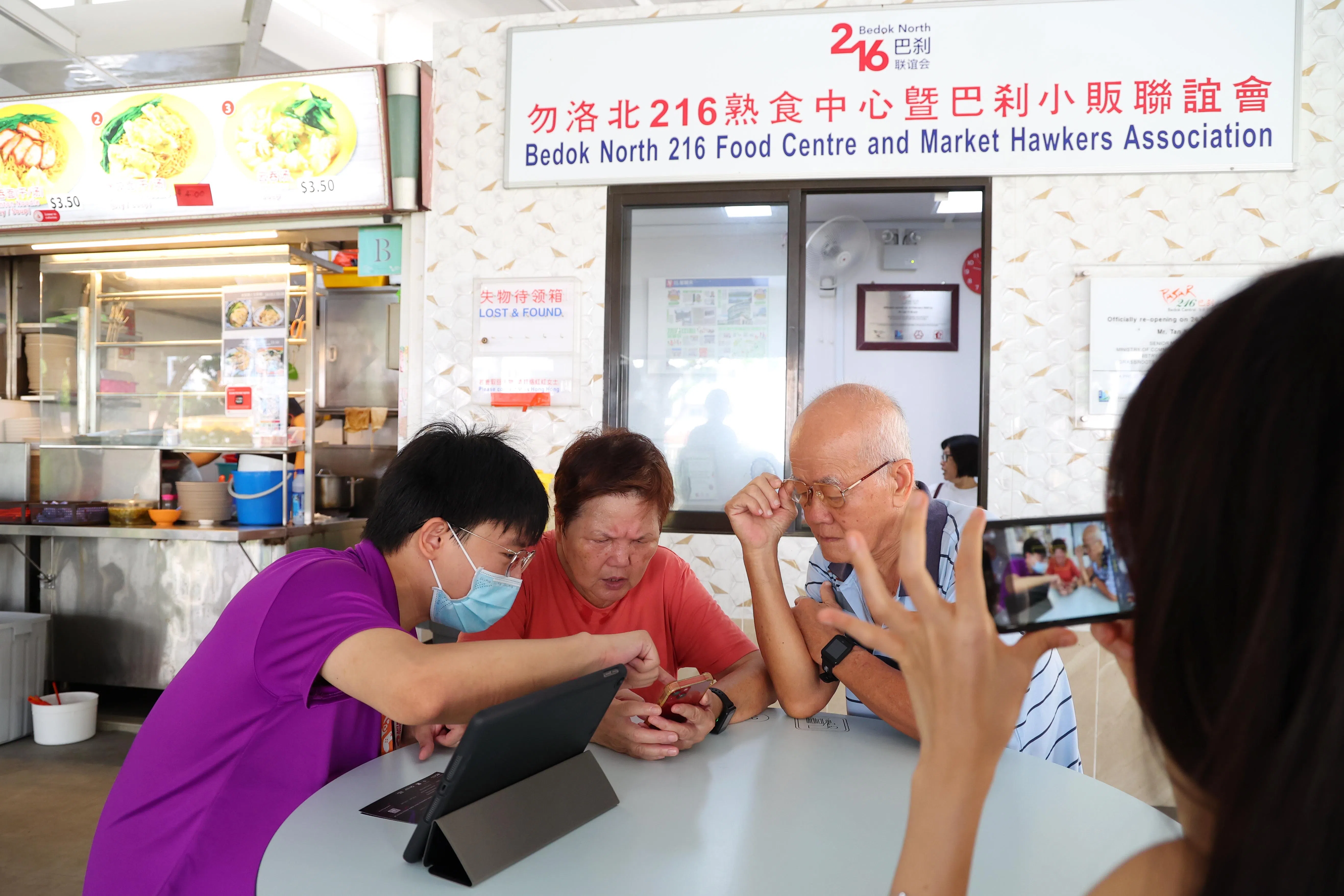 新加坡数码转型办事处数码大使林文兴（左起）教公众黄美锦和翁发生如何使用电子付款。（林明顺摄）