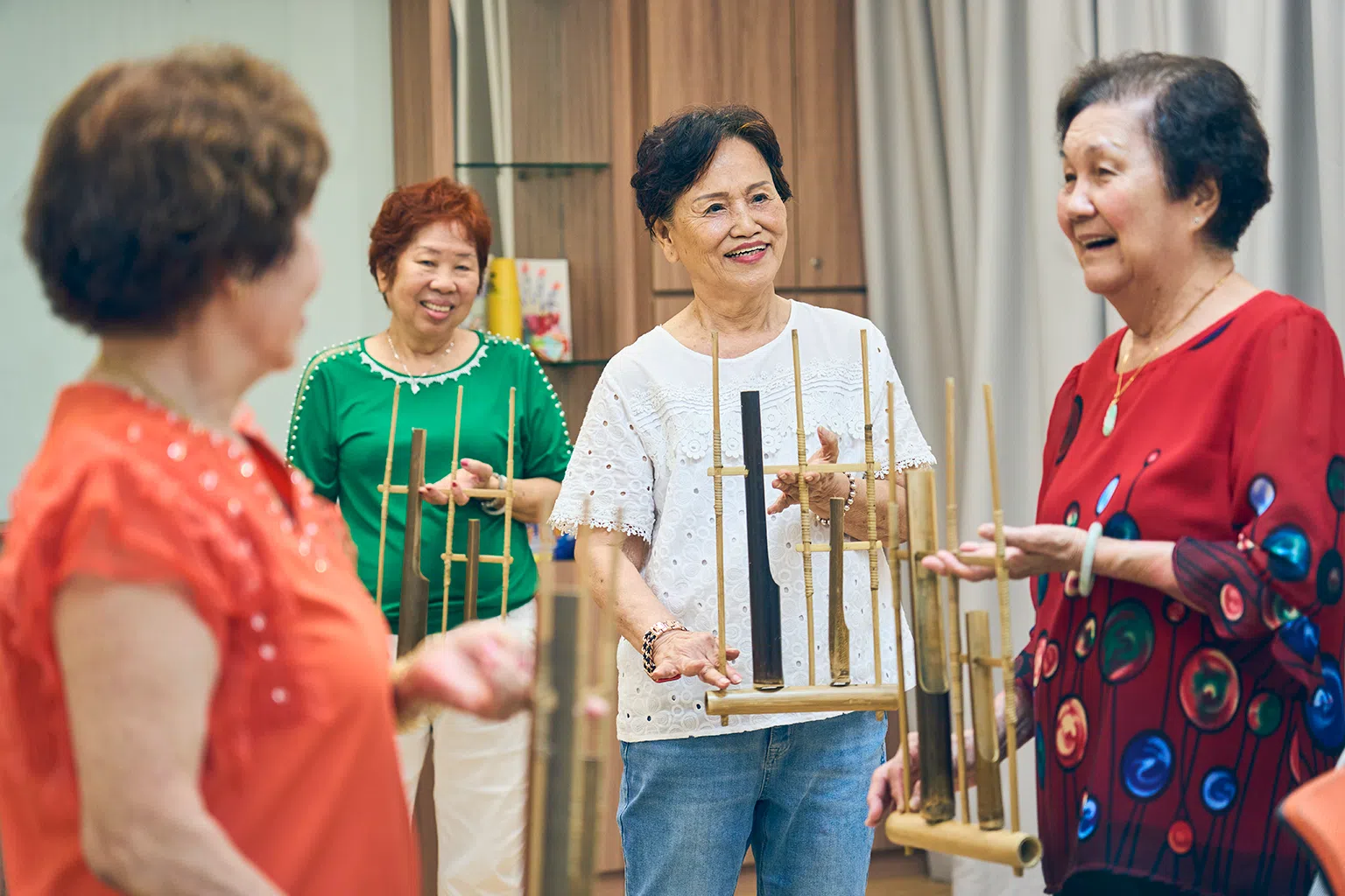 林玉英（右二）每周二固定参加乐龄活动中心举办的活动，比如学习演奏安格隆（angklung）。（图/新报业媒体）