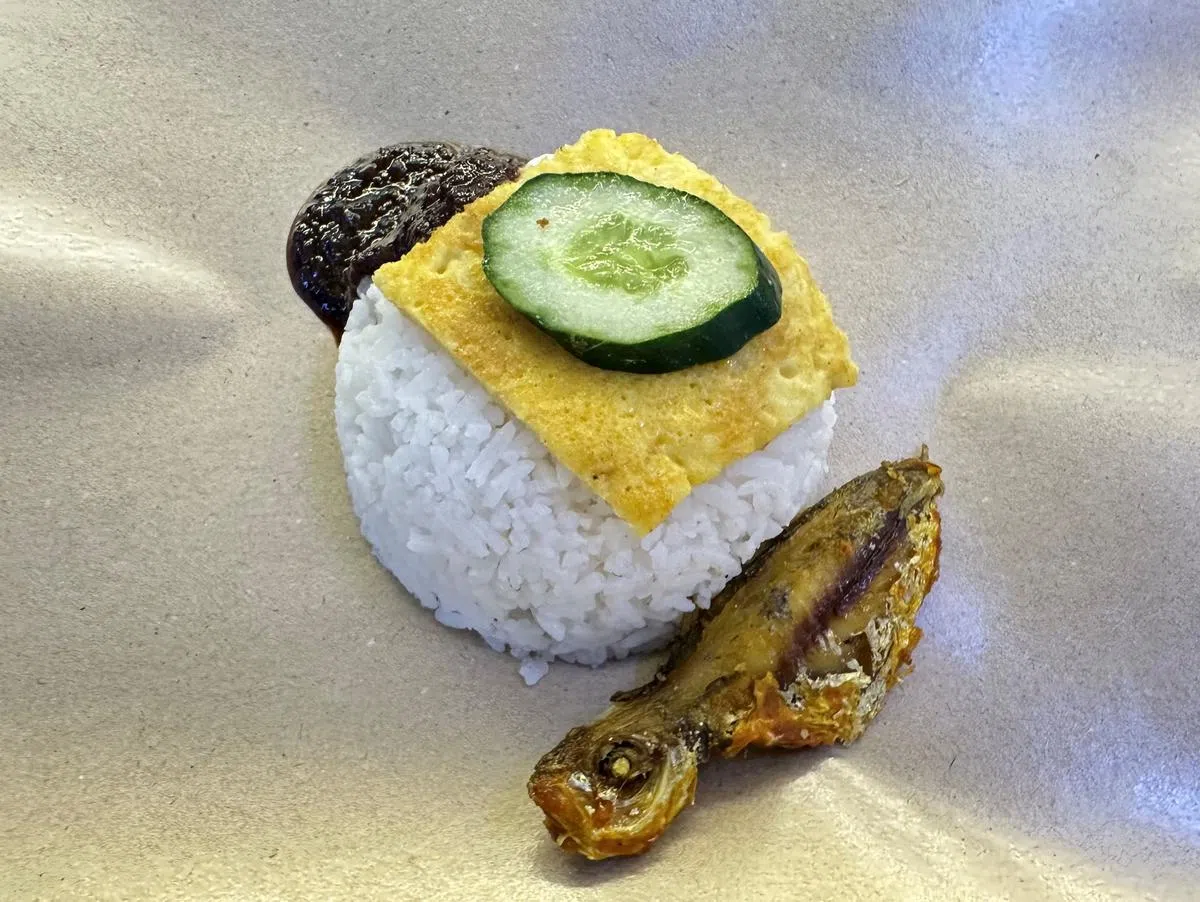 一元的椰浆饭包括饭、煎蛋、煎炸色拉鱼和参峇辣椒，淳朴实惠。（齐鲁摄）