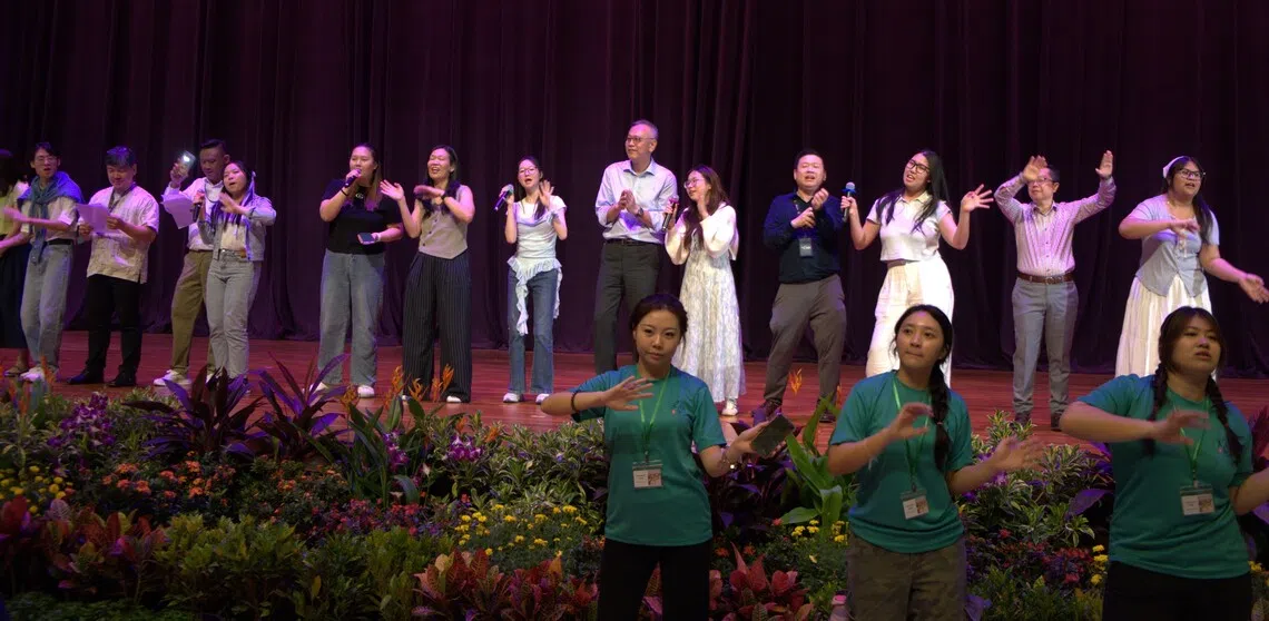 院长与师生一起合唱《细水长流》。舞台右二为中文系主任康格温博士，右六为义安理工学院院长林国强，右八为义安人文与跨学科学院院长杜安安。（义安理工学院中文系二年级商务专业摄影组摄）