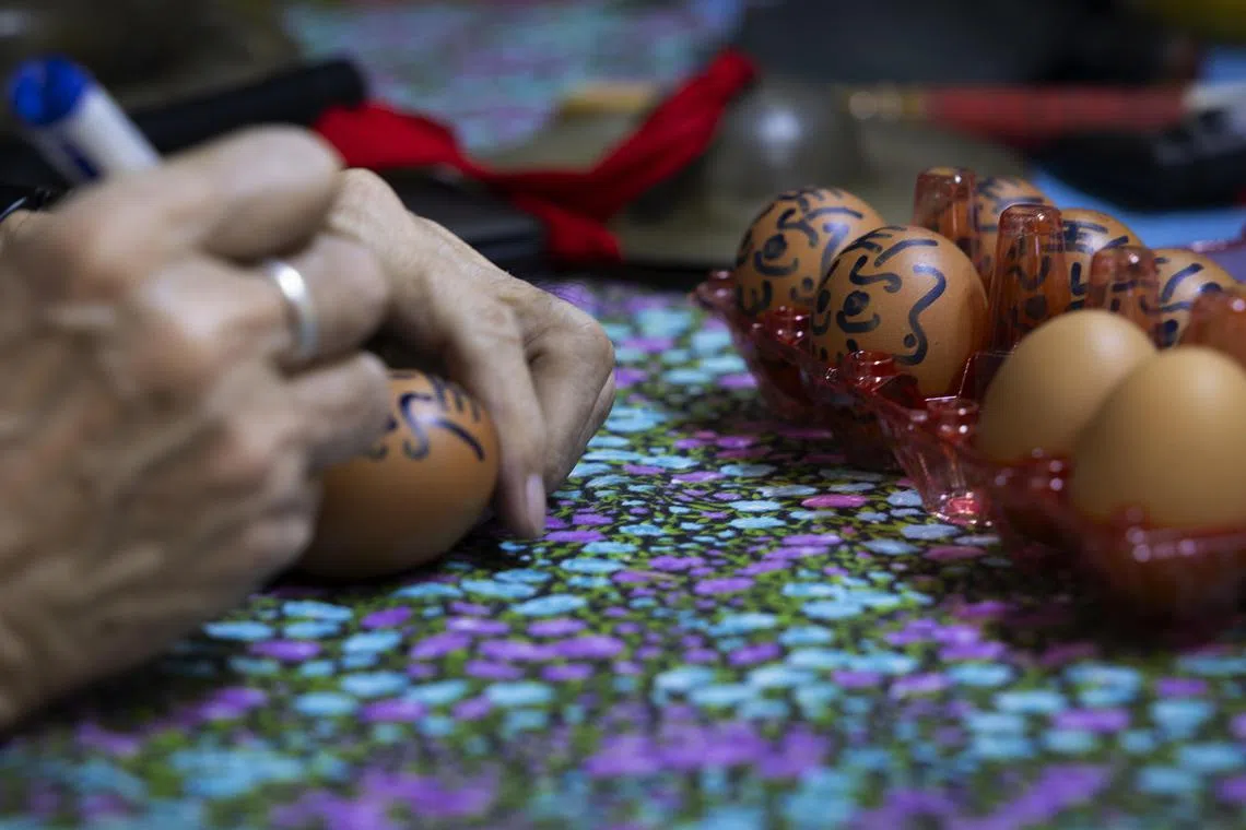 在鸡蛋上画上造型和表情各异的十殿阎罗。（龙国雄摄）