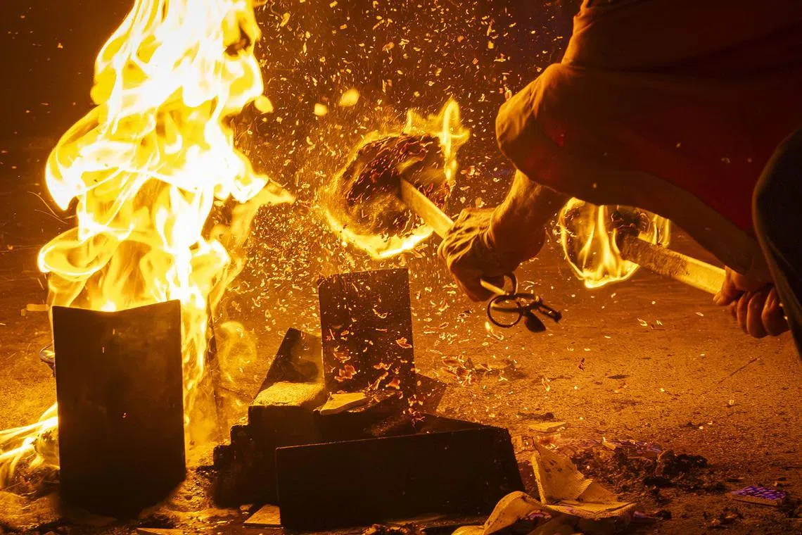 在烈焰之间做法事，如同与火斗快，稍有不慎就可能受伤。（龙国雄摄）