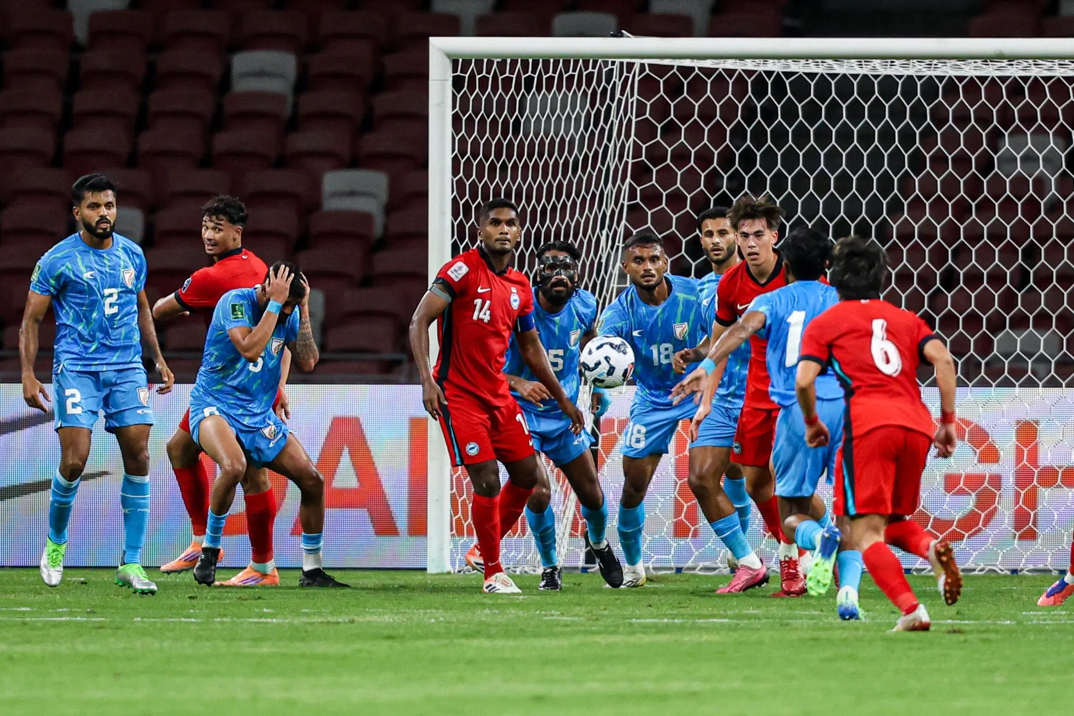印度（蓝衣）下半场少一人后反而攻势凶猛，一度让我国门前风声鹤唳。（关俊威摄）