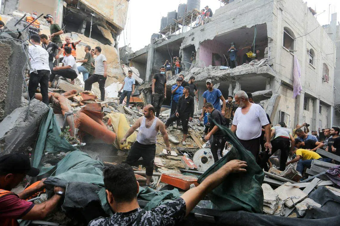 11月11日，在以色列袭击加沙地带南部拉法（Rafah）一所房屋后，巴勒斯坦人在废墟寻找伤亡人员。（路透社）