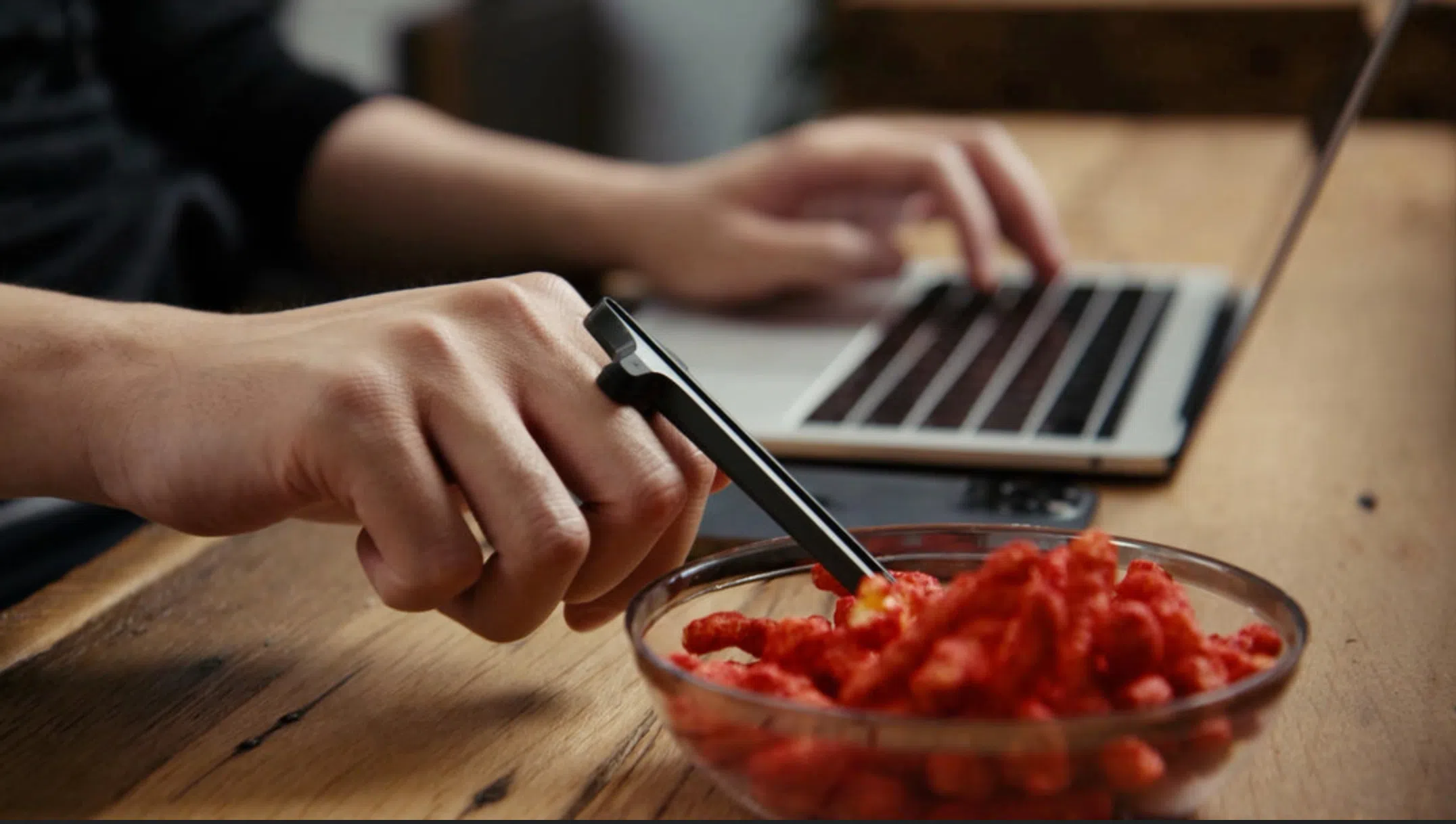 用“筷指”夹零食，办公不怕弄脏电脑键盘。（Snactiv）