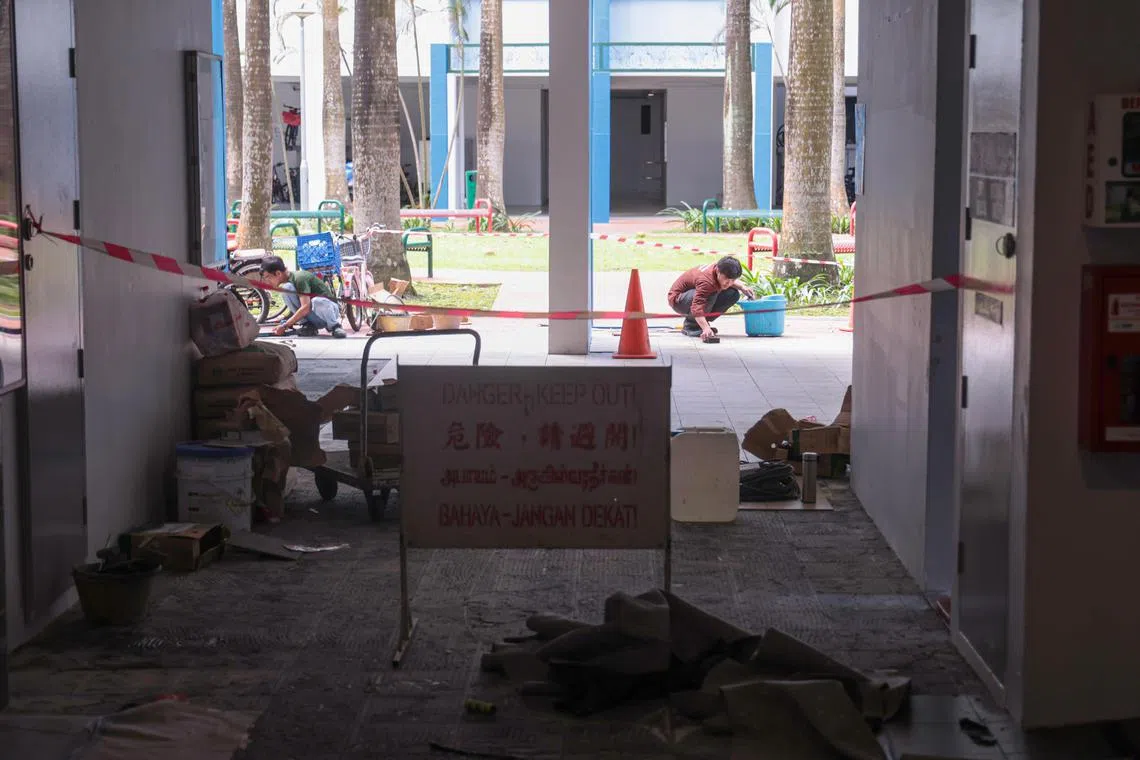 靠近信箱的位置设了封锁线暂时关闭，两名工人正在铺设地砖。（李冠卫摄）