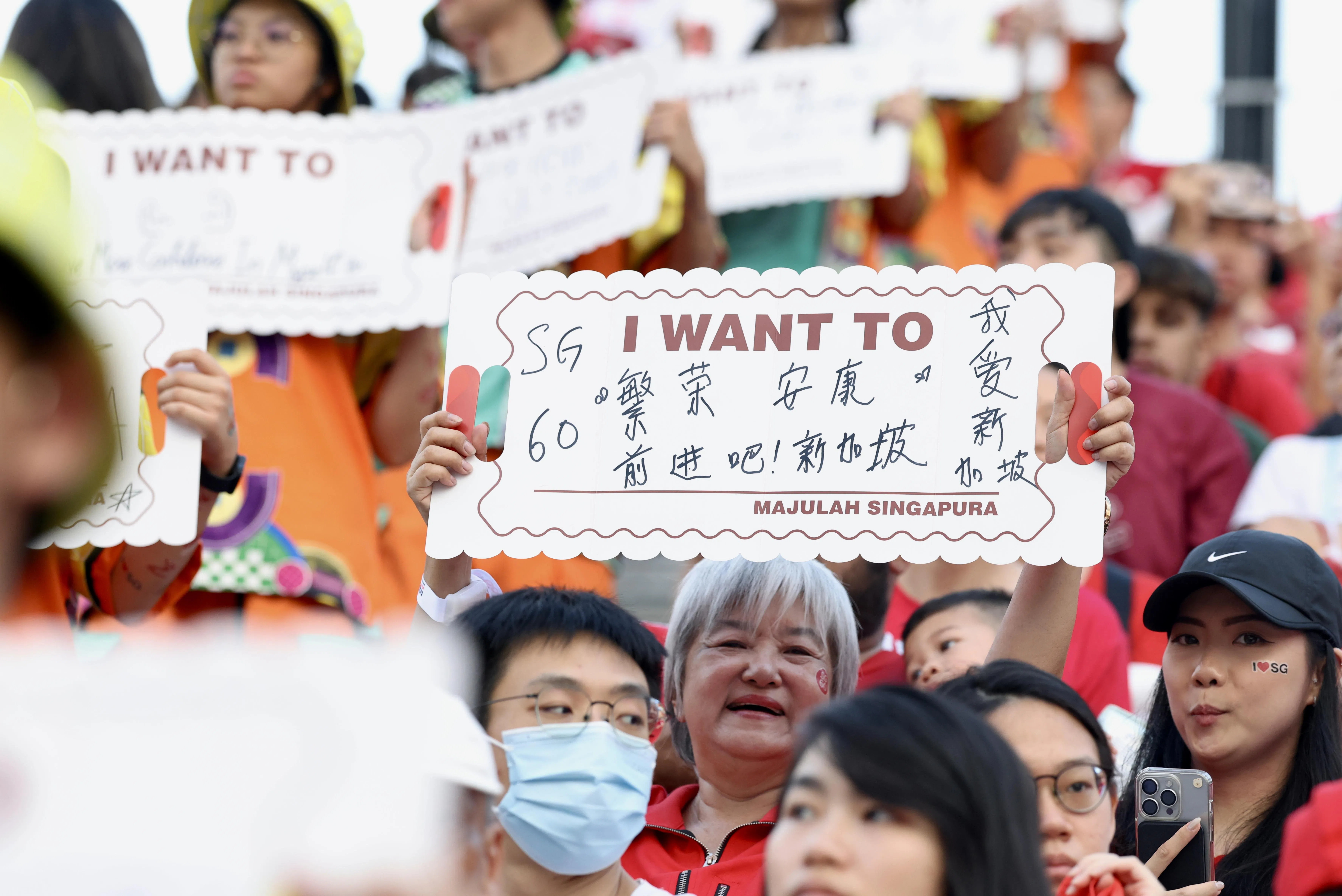 今年国庆庆典主办方特别设计“心愿牌”，让观众写下对新加坡和自己的期许，并在现场高举展示。一名观众写下：“繁荣、安康。前进吧！新加坡”。（陈斌勤摄）