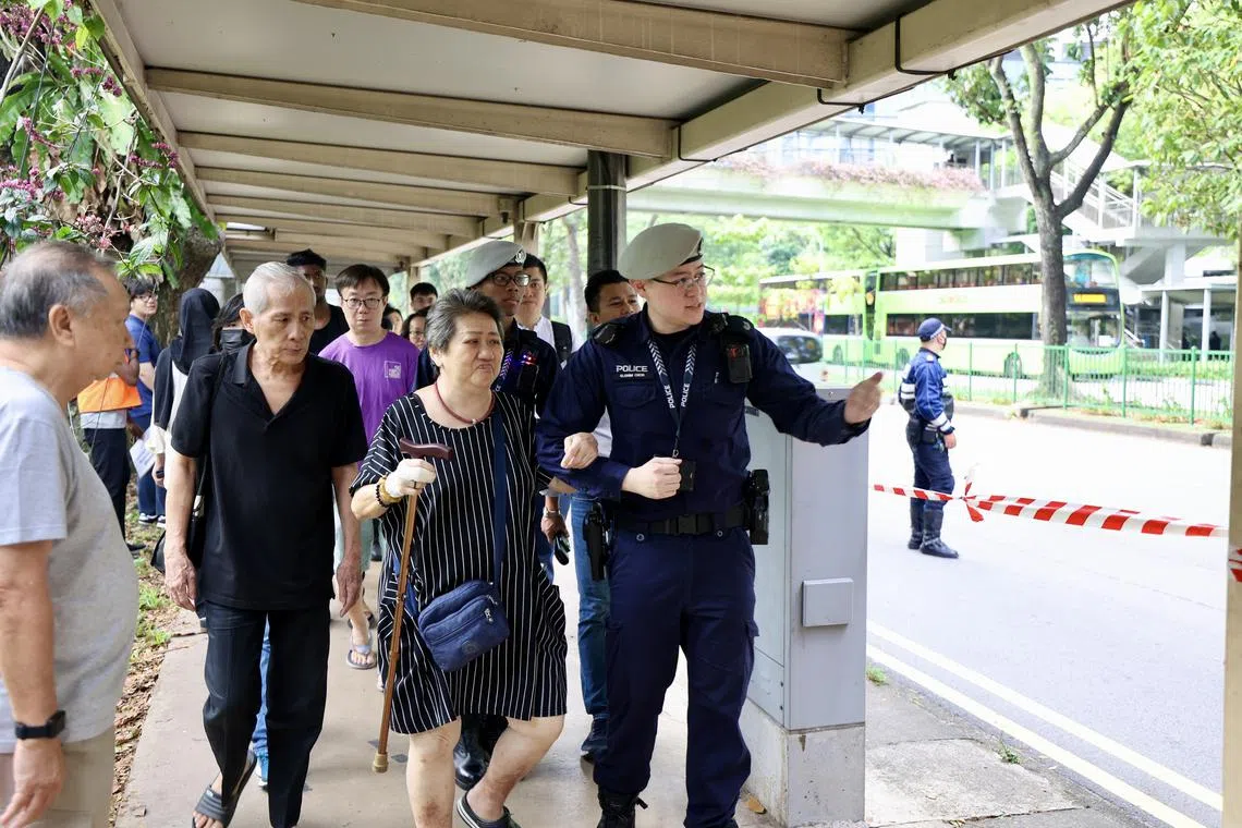 坐轮椅的年长妇人星期五从裕廊东地铁站下电梯后，因为路不平坦，便在公共交通保安指挥处警员的搀扶下站起来，缓慢走到接驳巴士站，过后再在众人帮助下上巴士，工作人员还把轮椅也一同抬到巴士上。（邝启聪摄）