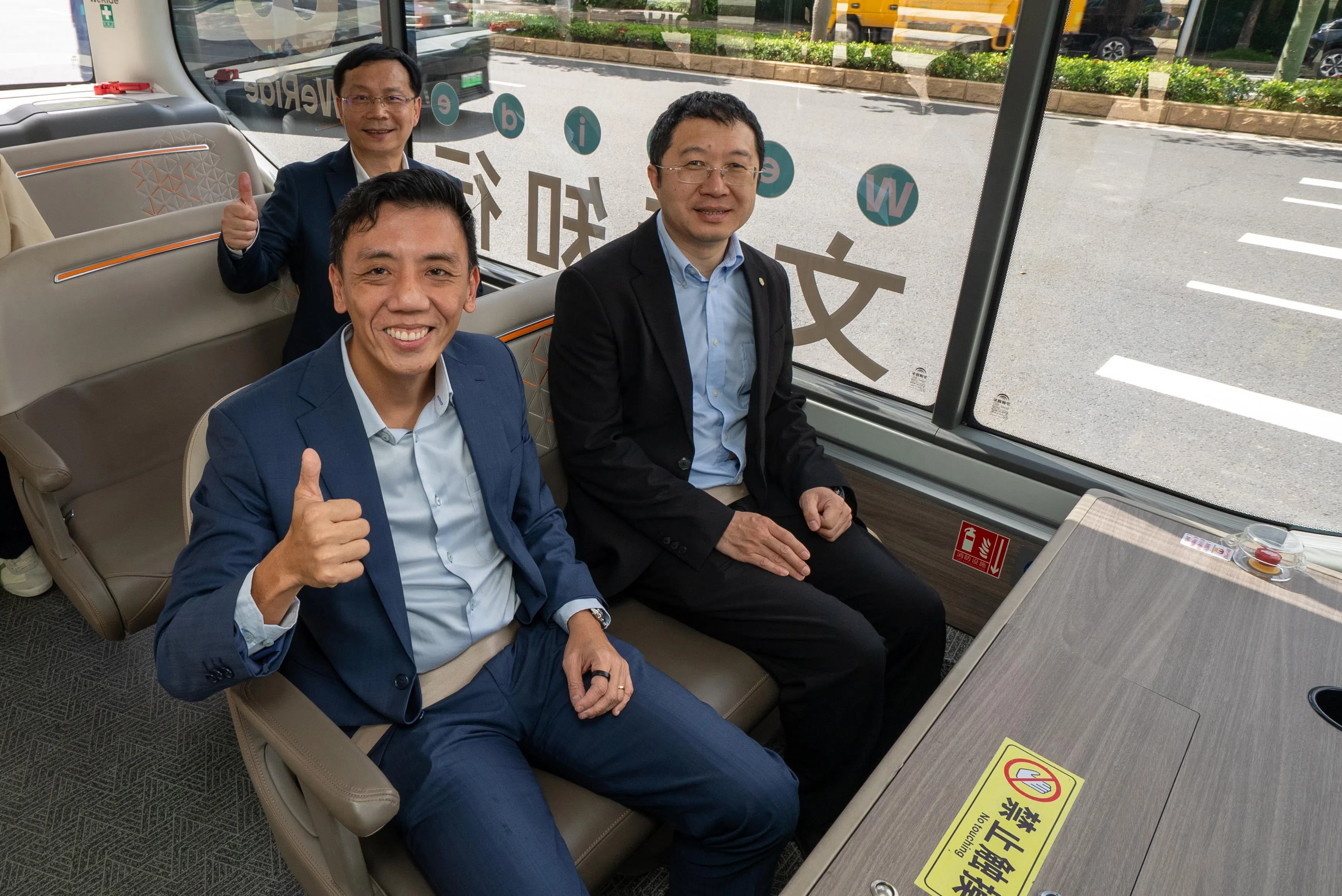 交通部代部长萧振祥（前排左）星期五（6月27日）到广州考察中国企业推出的自动驾驶服务。图为他在广州国际生物岛，与自驾科技企业文远知行创始人兼首席执行官韩旭（前排右）和文远知行新加坡总经理许开新博士（后排）一起体验自驾小巴。（交通部提供）