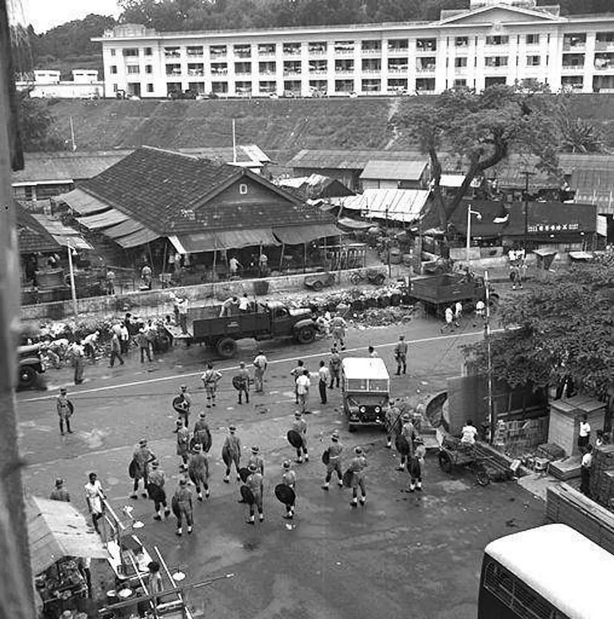 1961年的珍珠巴刹，当时全国日薪工友罢工， “新”员工在警方保护下如常工作。（档案照）