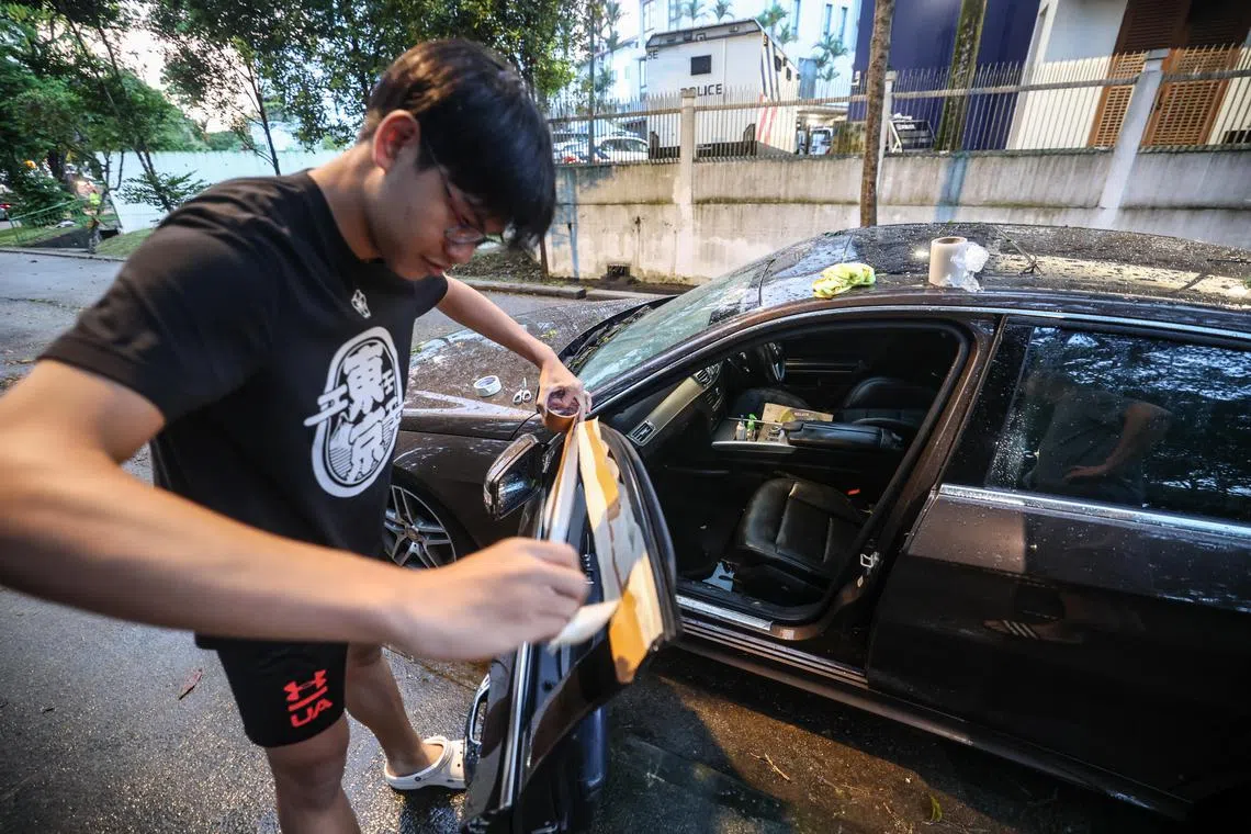 引擎发出怪声、车窗和后备箱关不上，黄亿和和家人只能暂时尝试用胶带修理车窗，等待拖车把车拖走。（关俊威摄）